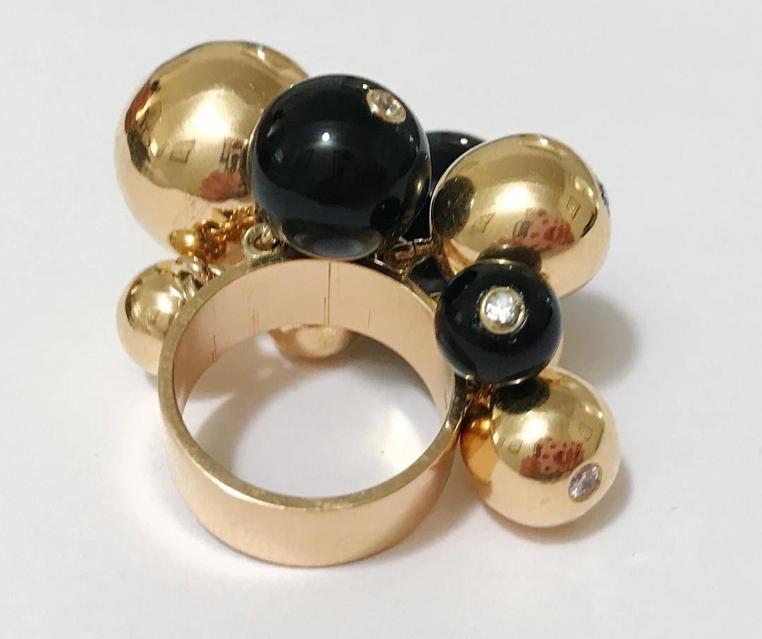 A show stopper!  So Chic! A stunning statement piece.

18kt Yellow Gold and Onyx Tassel Ball Ring.  Each of the various sized nine balls is set with a bezel set Diamond.   Signed A Clunn.

There are nine tassel balls with bezel set diamonds on each