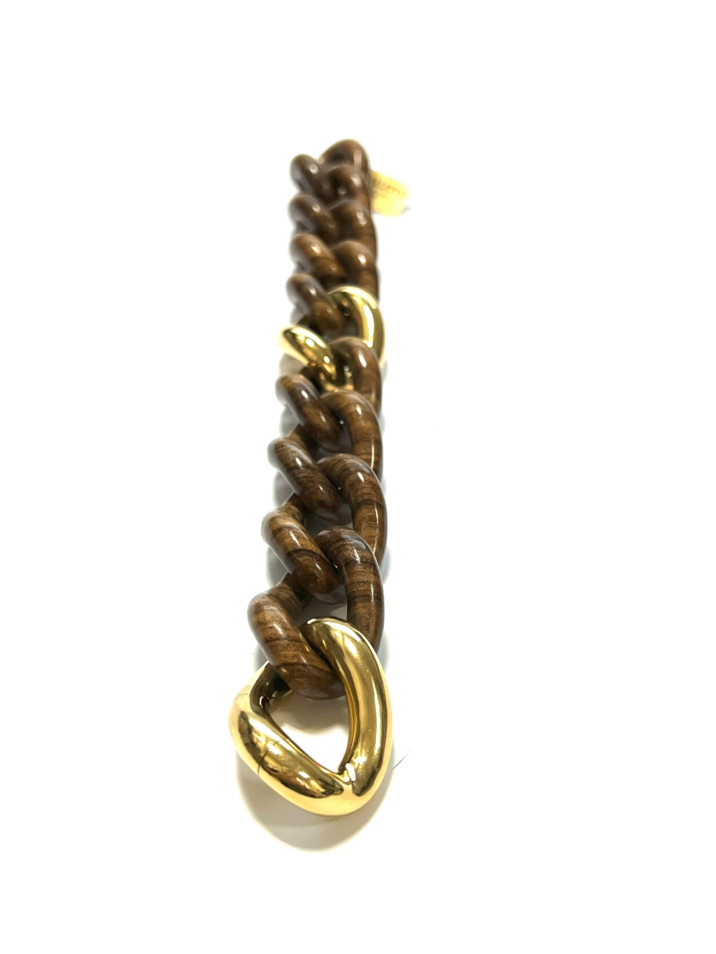 Bracelet à gros maillons en or jaune 18 carats et en grosemette de Palissandre
Ce bracelet a une ouverture cachée.
Poids total gr. 53,3
Poids d'or gr. 23,7
Longueur cm. 21
Tampon 10 MI, ITALIE, 750

