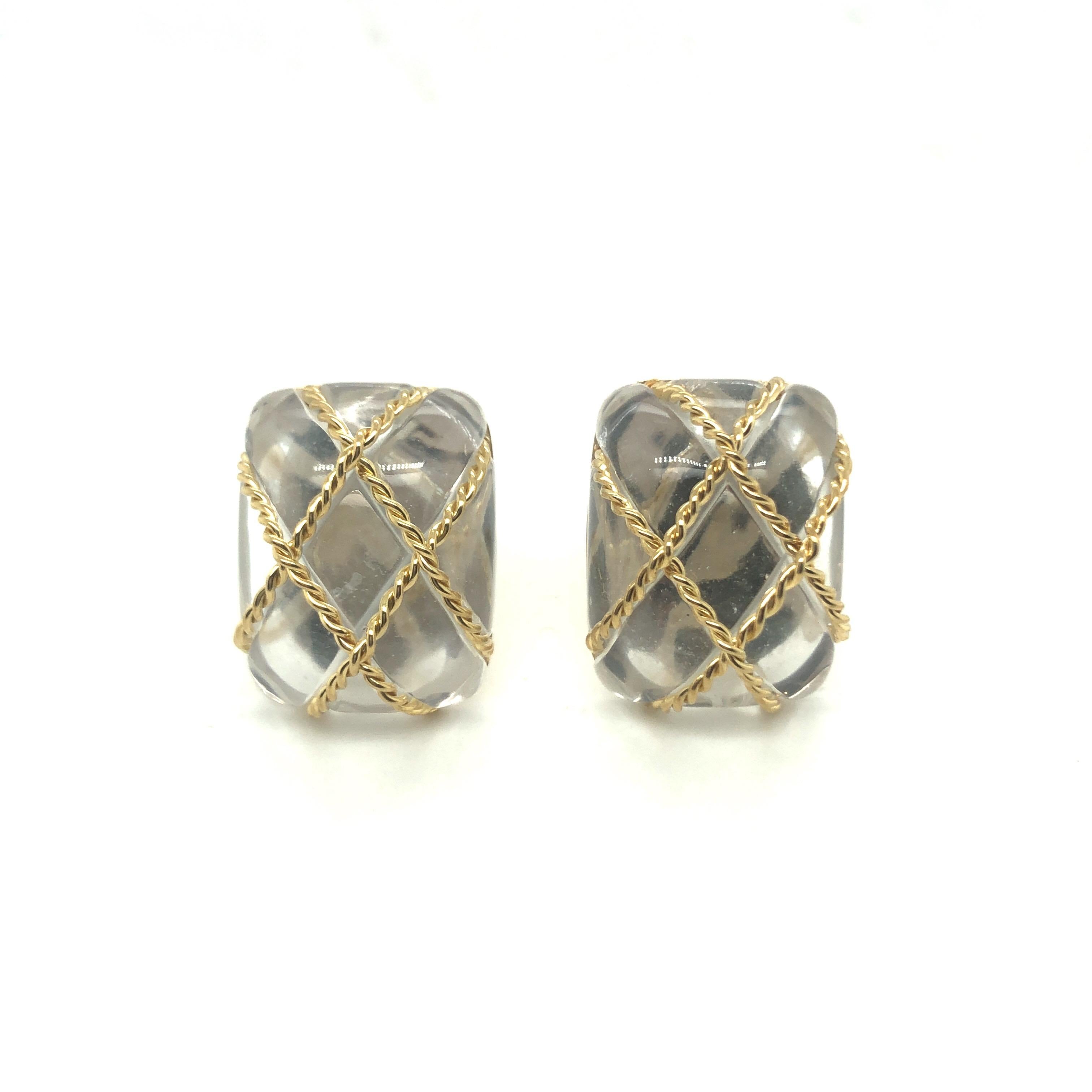 Fabulous pair of 18 karat yellow gold and rock crystal cage earrings by American jeweler Seaman Schepps.
Crafted in 18 karat yellow gold, each earring featuring a large cushion-shape rock crystal cabochon trapped in a cage of twisted gold wires. The