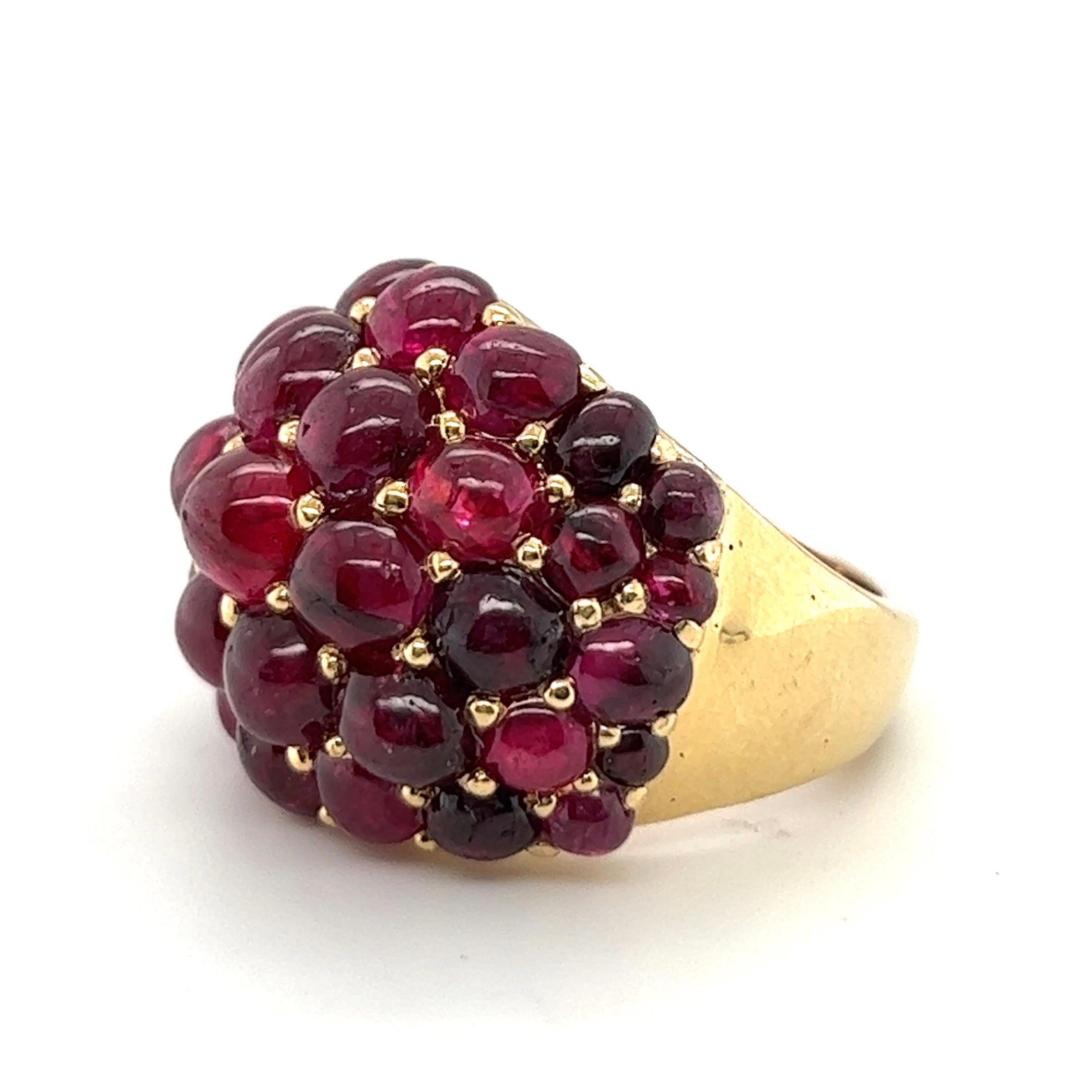 Ravishing 18 karat yellow gold and ruby cocktail ring.
Crafted in 18 karat yellow gold, the dome fully set with numerous round and oval ruby cabochons of slightly different sizes and red shades.
This statement ring is just perfect for day and
