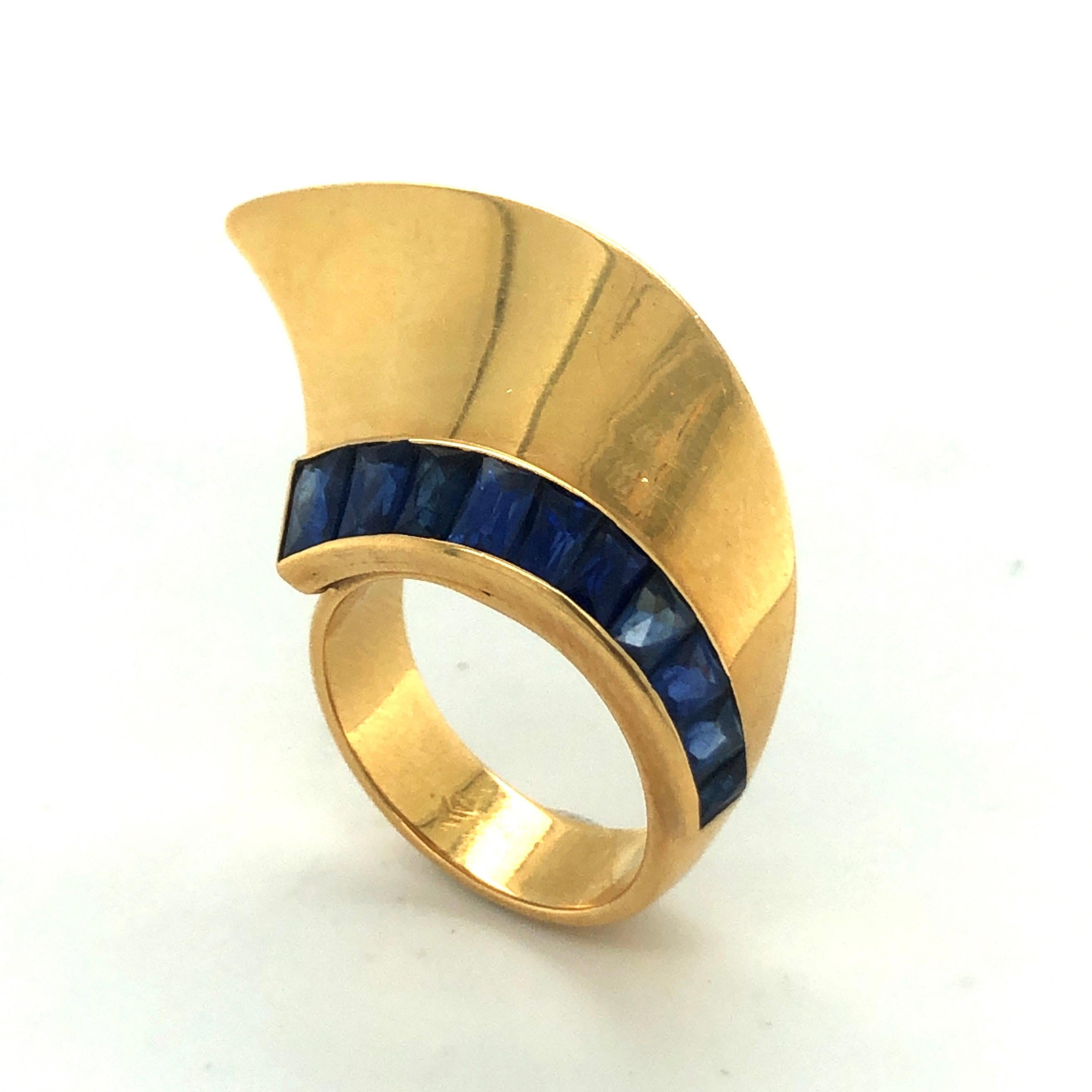 Whimsical 18 Karat Yellow Gold and Sapphire French Retro Ring, 1940s.
Asymmetrical retro ring set with a line of 10 natural French cut blue sapphires totalling about 3 carats. It is suitable for day and night wear and will add a special twist to