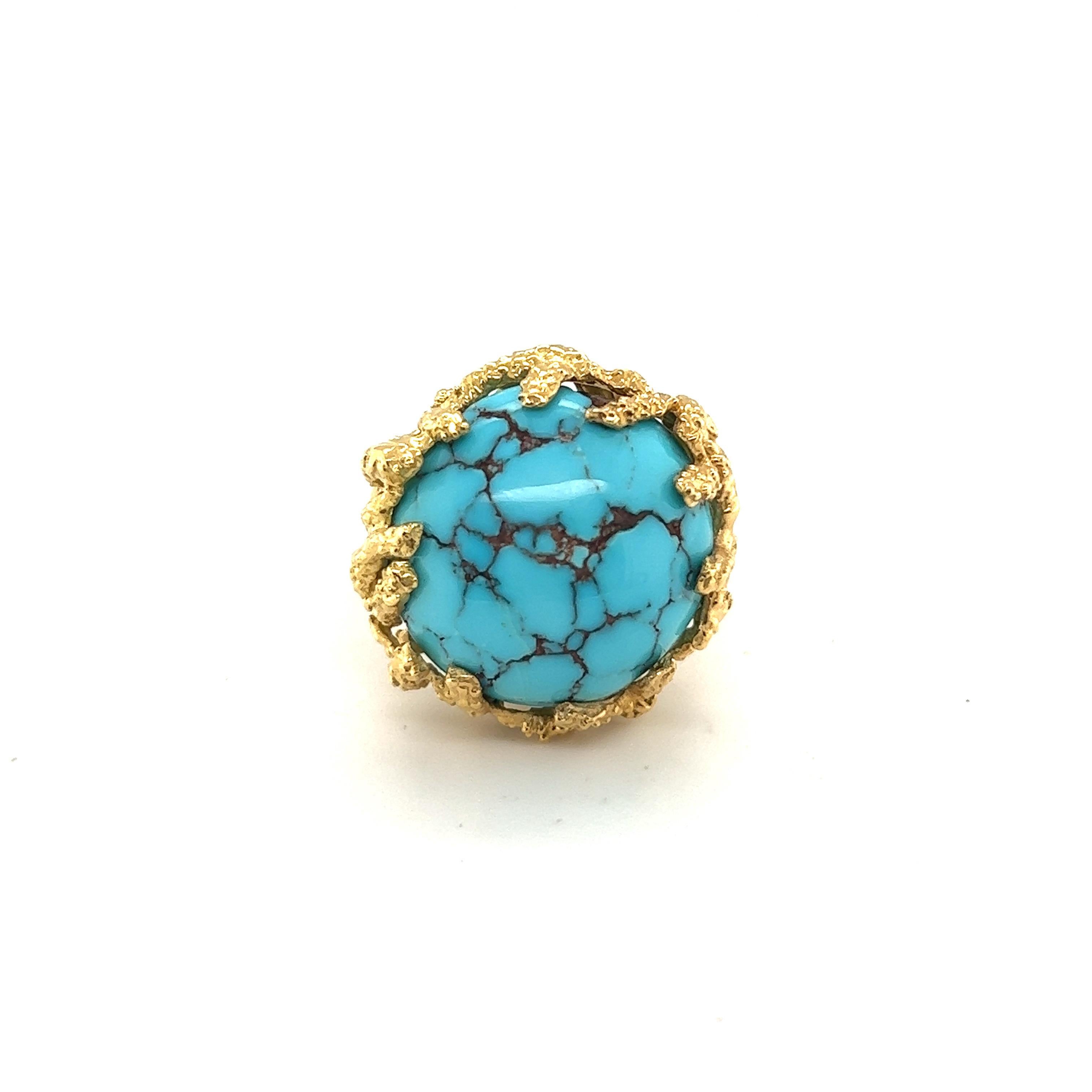 Glamorous and ladylike 18 karat yellow gold and turquoise cocktail ring from the 1960s. 

Crafted in 18 karat yellow gold, this eye-catching ring is set with a turquoise cabochon of circa 1.7 cm / 0.67 inch diameter. The structured appearance of the