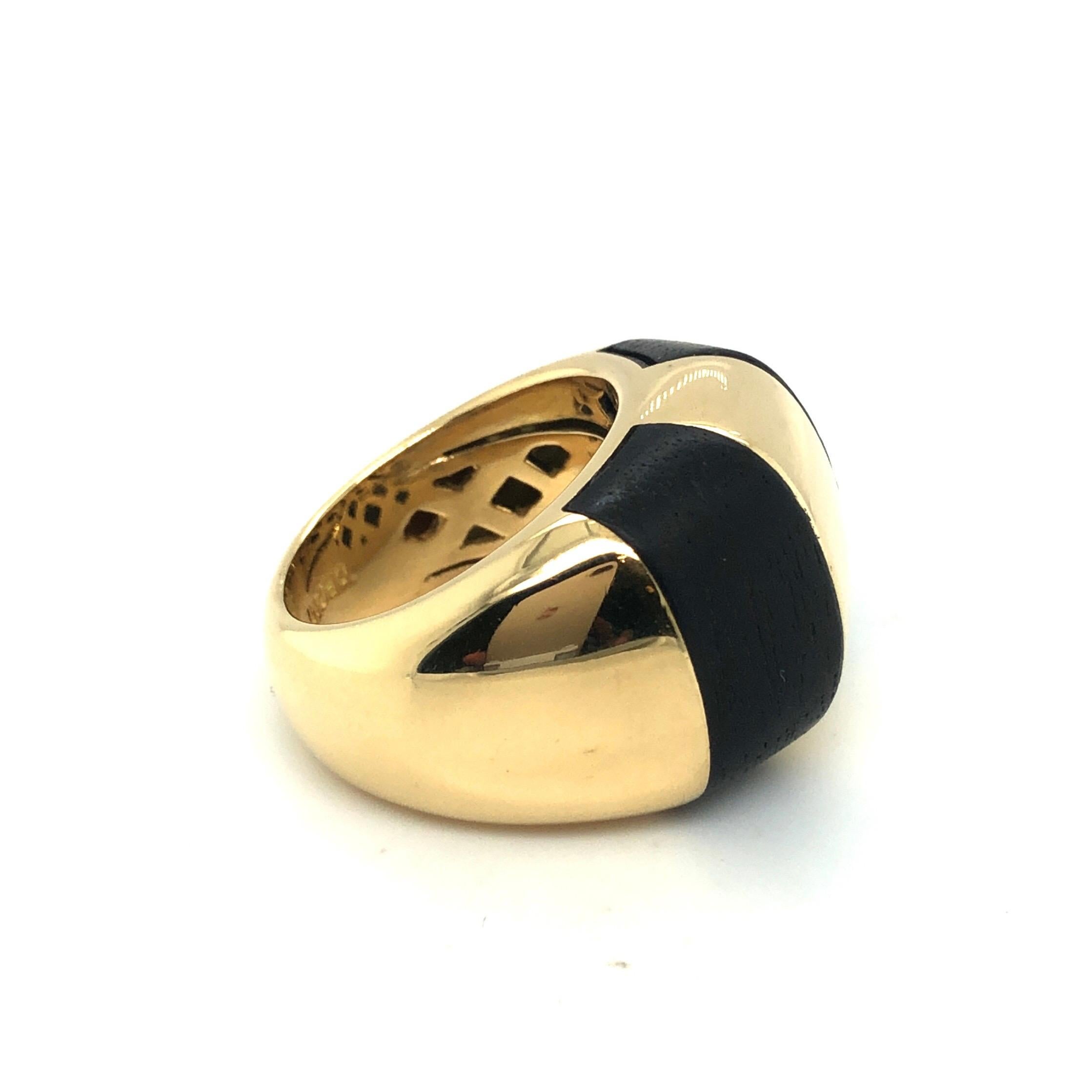 Striking 18 karat yellow gold and wood cocktail ring from the 1990s.
Crafted in 18 karat polished yellow gold, this statement ring is set with two ebony wood inlays. It has been recently professionally cleaned and polished and is therefore in