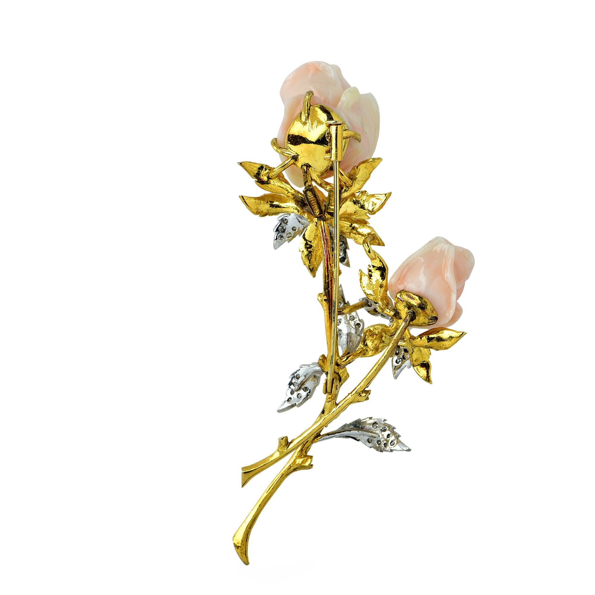 Beautiful brooch pin crafted in 18K yellow gold showcasing two rosebuds finely crafted in dainty pink angel skin coral, with leaves adorned with 38 round brilliant cut diamonds weighing .40 carats. This brooch measures 3.5 inches in length and 2.1