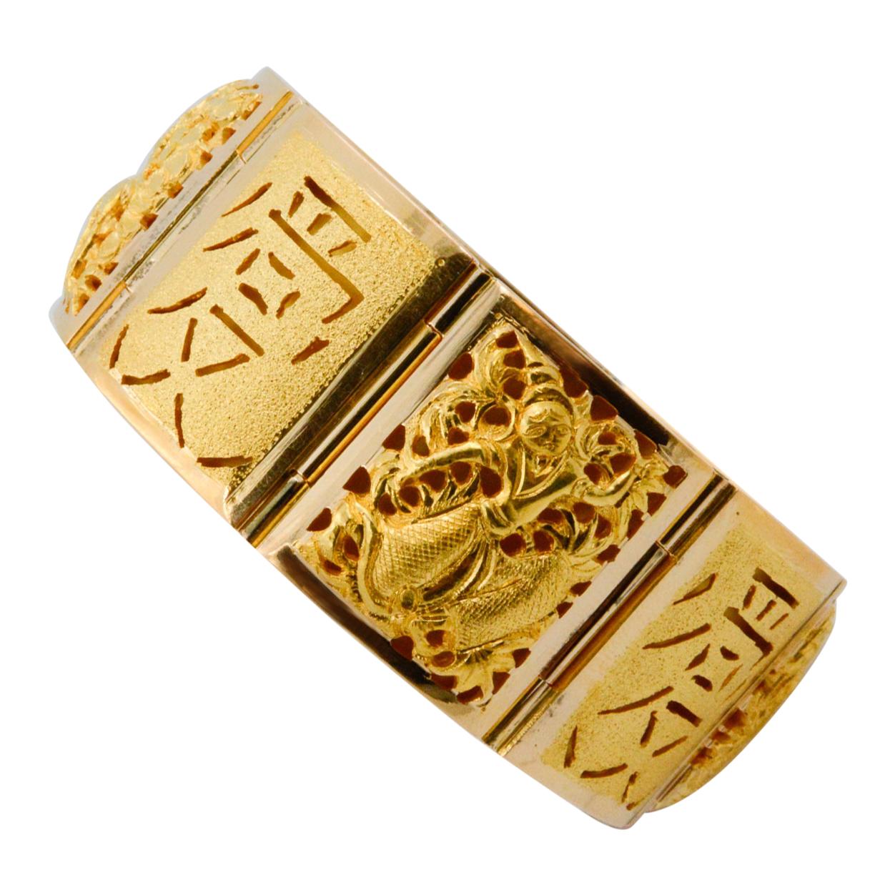 This 18 karat yellow gold Asian bracelet features four season design panels among the total eight panels. The bracelet is wide, measuring at 25mm across. 

