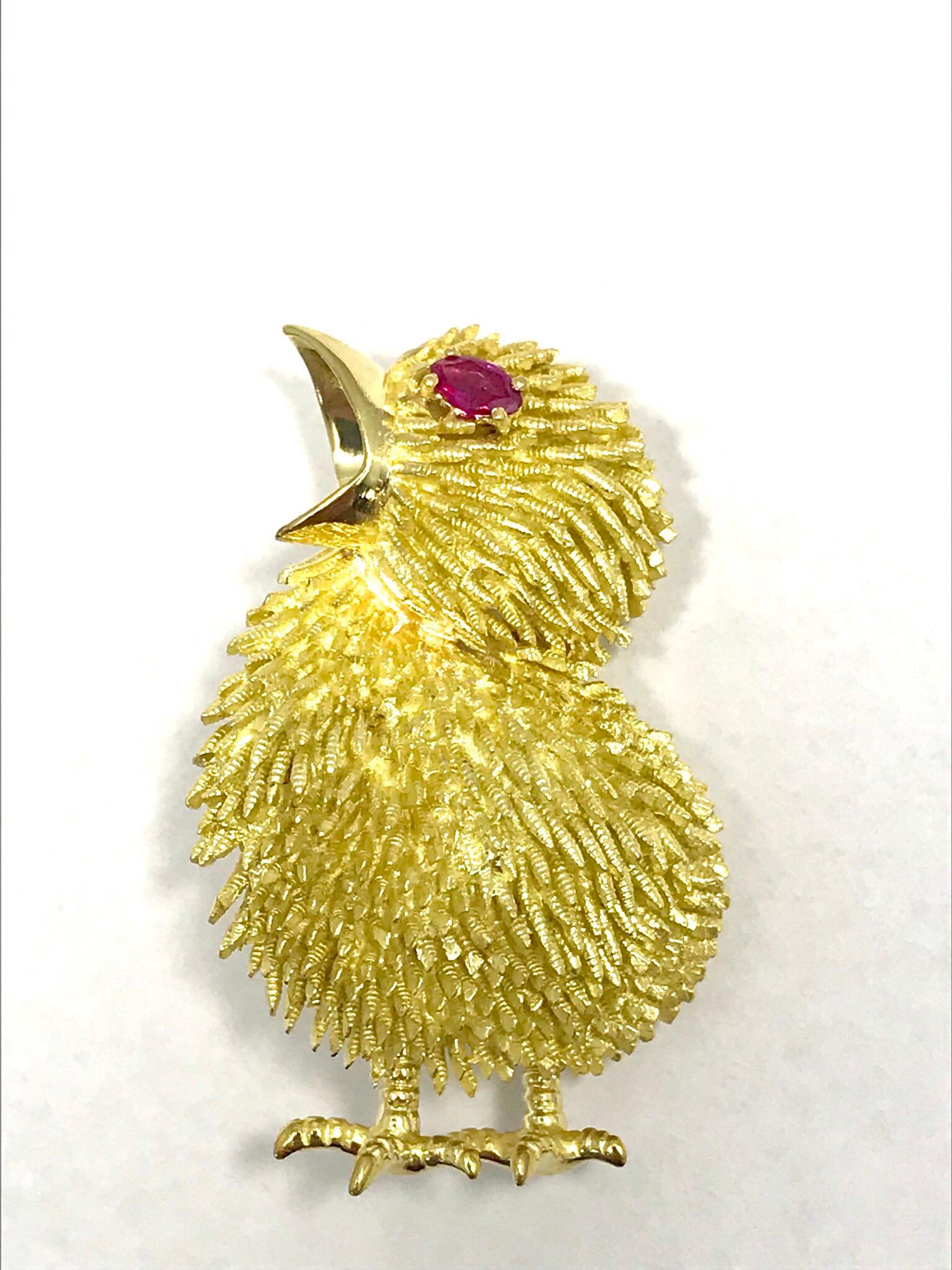 This is a beautifully crafted 18 karat yellow gold baby chick brooch with a marquise shaped Ruby eye.  The ruby weighs 0.15 carats, and is a vibrant red color.  The body of the chick is made up of textured gold made to mimic the soft feathers of a