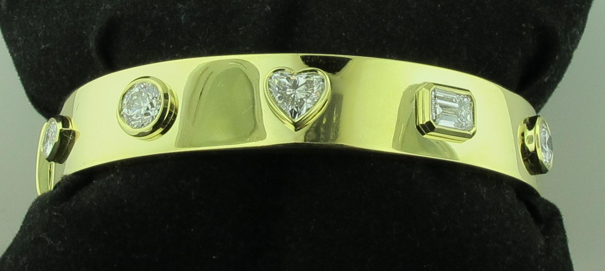Set in 18 karat yellow gold are 5 multi-shaped diamonds:  Two round brilliant cut diamonds, one heart shaped diamond, one emerald cut diamond and one marquise cut diamond.  Total diamond weight of 3.81 carats.