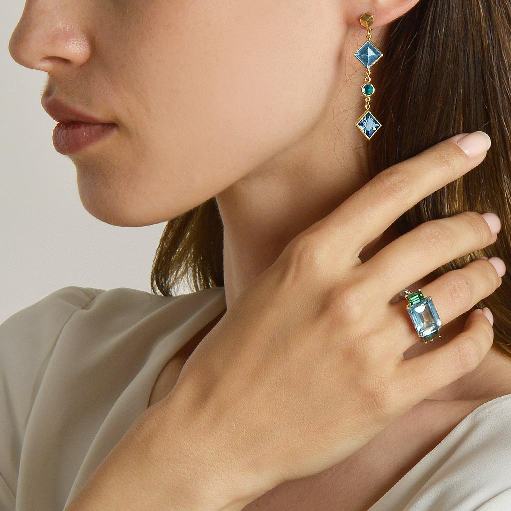 18kt yellow gold Florentine earrings with bezel set emerald-cut blue topaz and round tsavorite garnets, and signature Brillante® motif. 

Inspired by the Garden of the Iris, the Florentine collection pairs bold color combinations of geometric