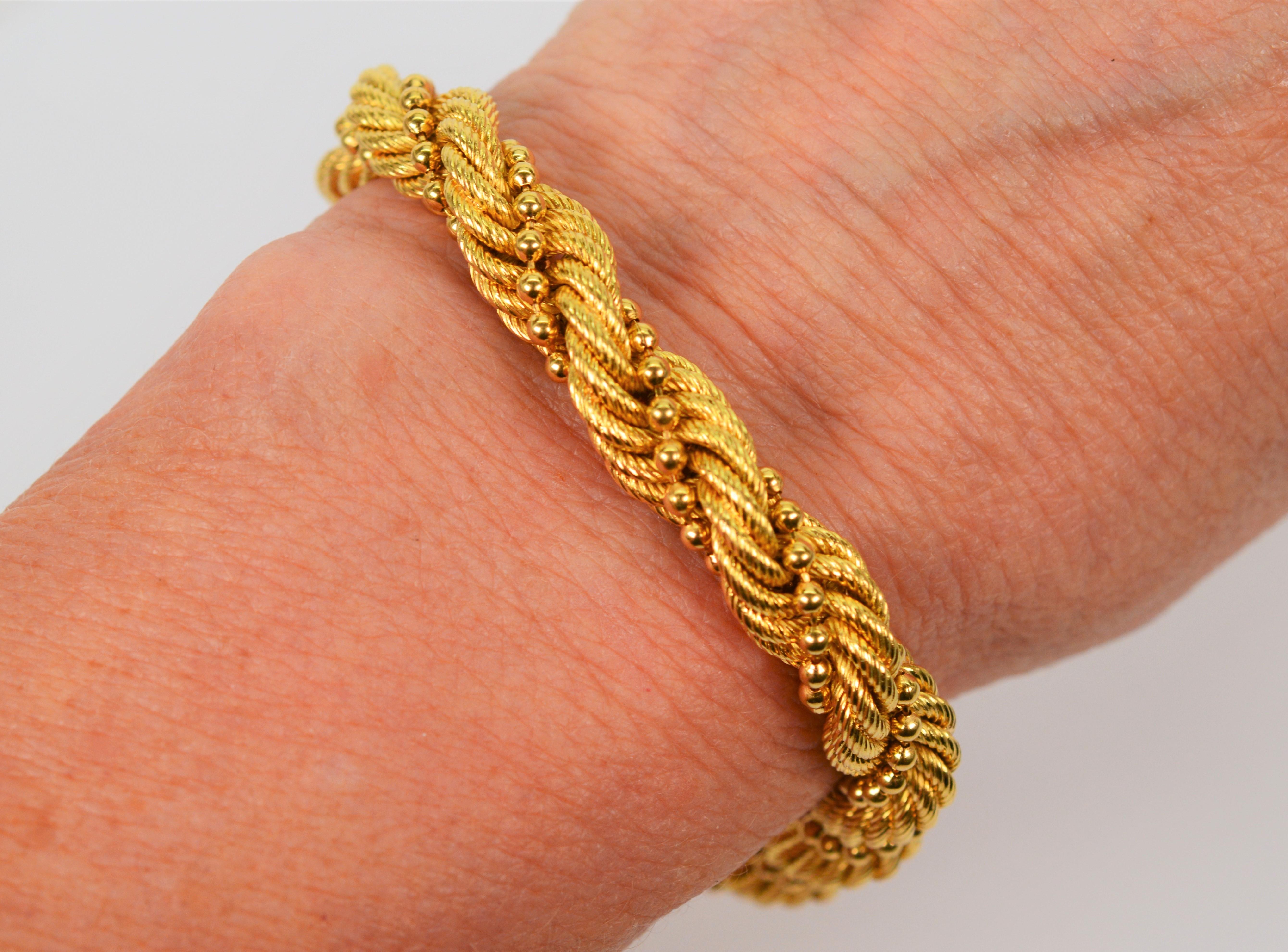 Drape your wrist with bold braided strands of bright 18 karat yellow gold. As a jewelry wardrobe leader, this flexible gold rope bracelet at a generous 7.3mm is intertwined with a single strand of petite gold beading which adds elegance to the