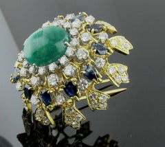 18 Karat Yellow Gold Brooch with Diamonds, Sapphires and a Cab Emerald Center