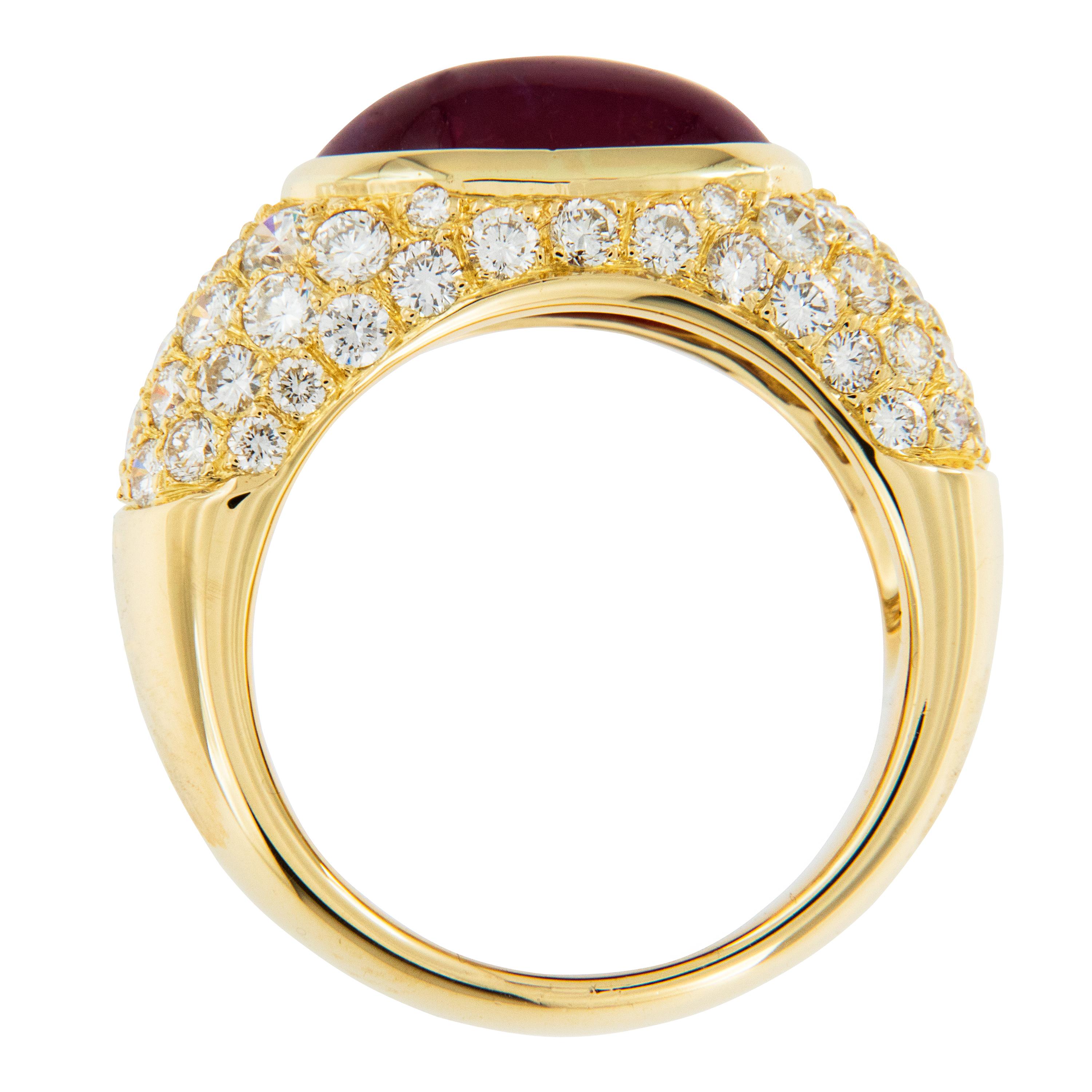 The timeless Bombe' style of this ring will never go out of style! Comprised of 18 karat yellow gold centered around a gemmy oval cabochon ruby = 5.22 Carat & 64 rbc diamonds pave' set = 1.78 Cttw. The smooth rounded look & exceptional color of this