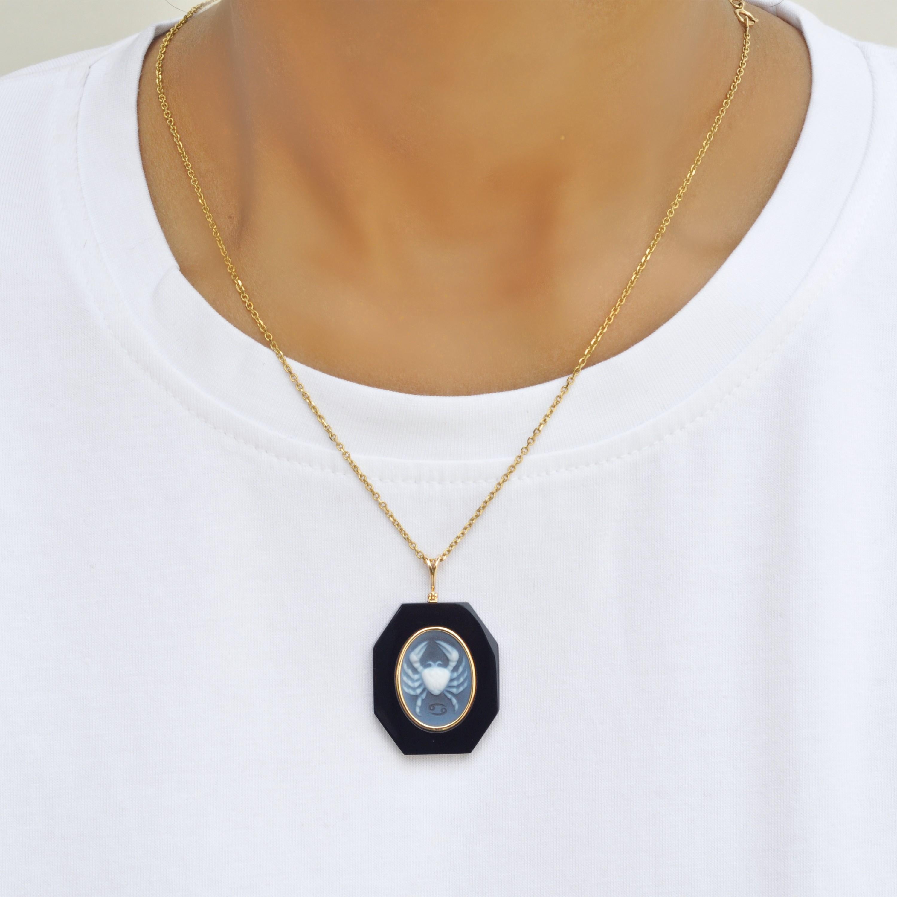 18 karat yellow gold cancer zodiac agate cameo black onyx pendant necklace. 

This exquisite pendant showcases a stunning combination of contemporary design and timeless elegance. Crafted in 18K gold, the piece features a sleek loop from which