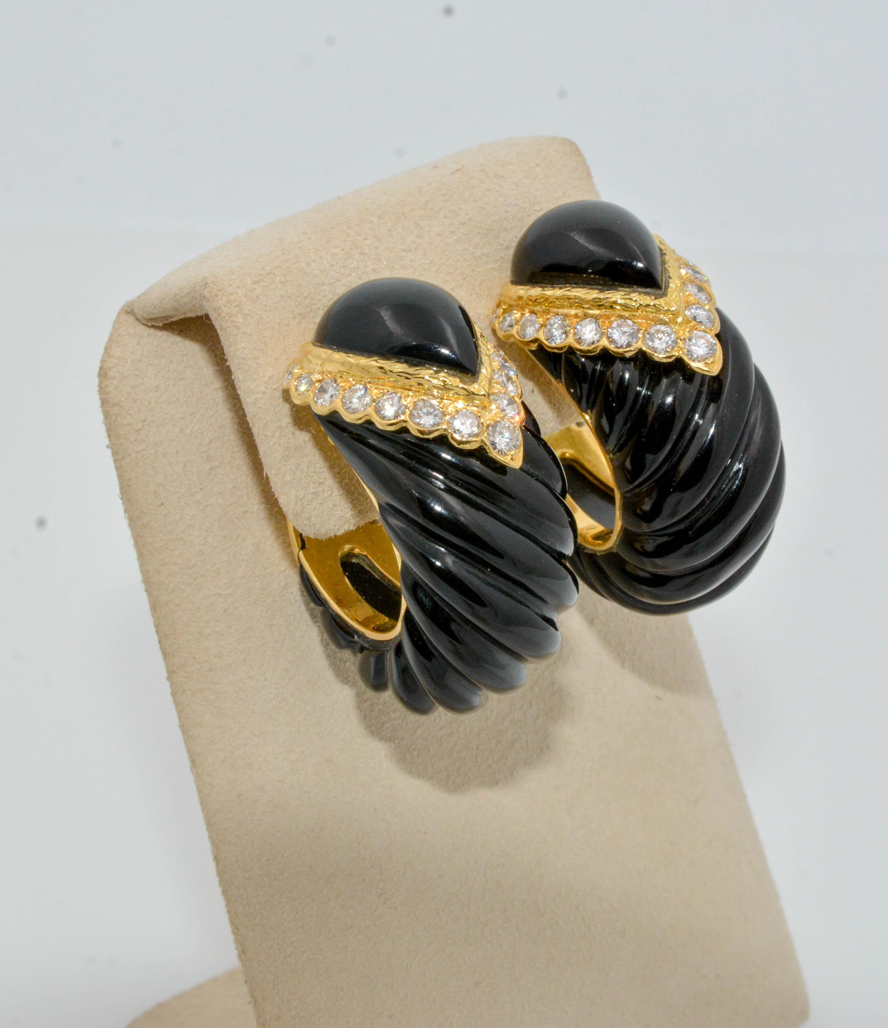 These dark and elegant earrings make an alluring statement. Covered in 18K yellow gold with carved onyx and 30 round diamonds 1.78ctw these clip back hoops convey power and strength. 

Perfect for the lady looking for eccentric hoop earrings!
