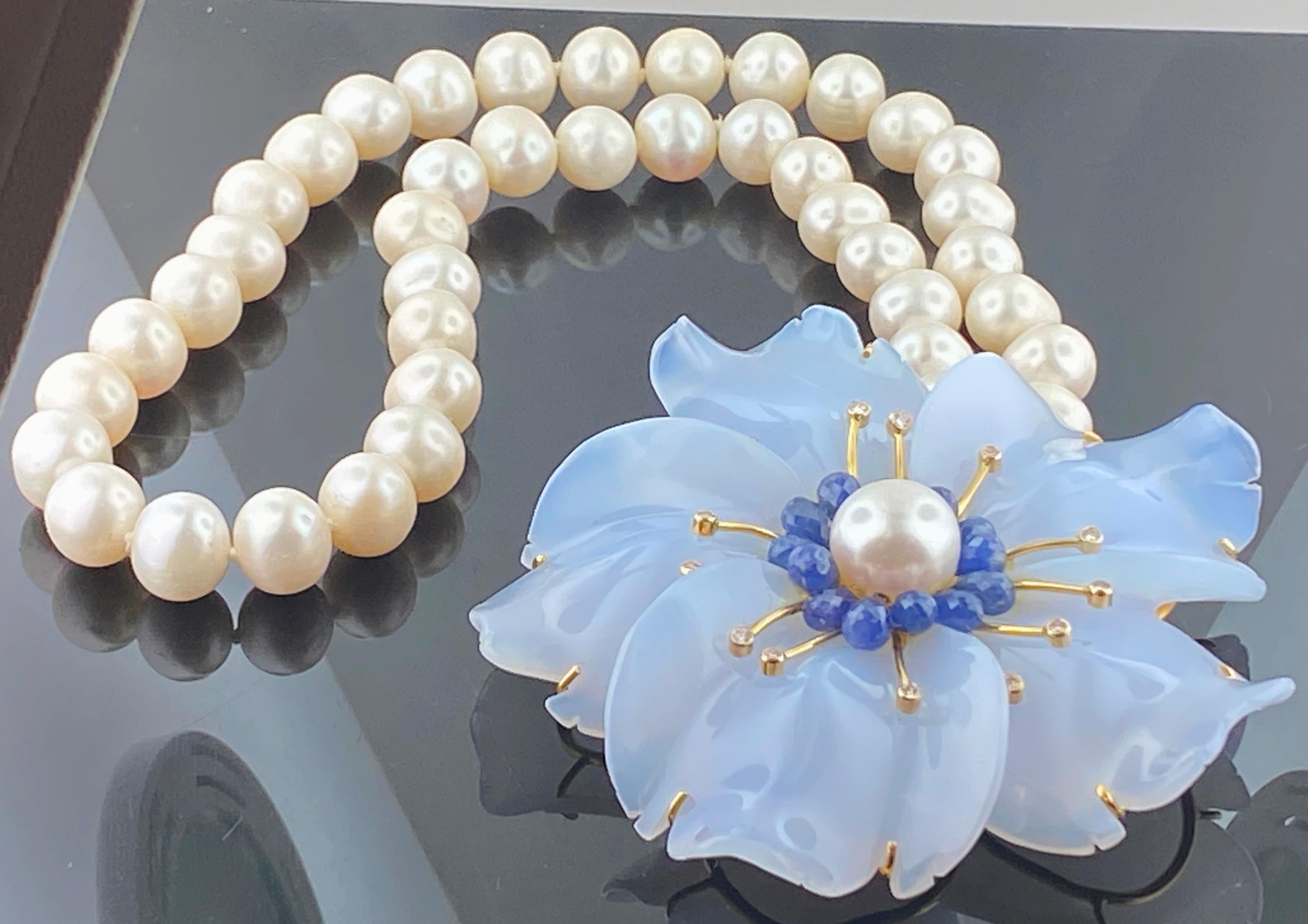 18 Karat Yellow Gold Chalcedon Flower, Pearls, Sapphires and Diamond Necklace
42 Freshwater Pearl strand
13 Sapphires weighing approximately 8.58 carats
13 Round brilliant Diamonds weighing approximately 0.39 carats
Color Range I and Clarity range