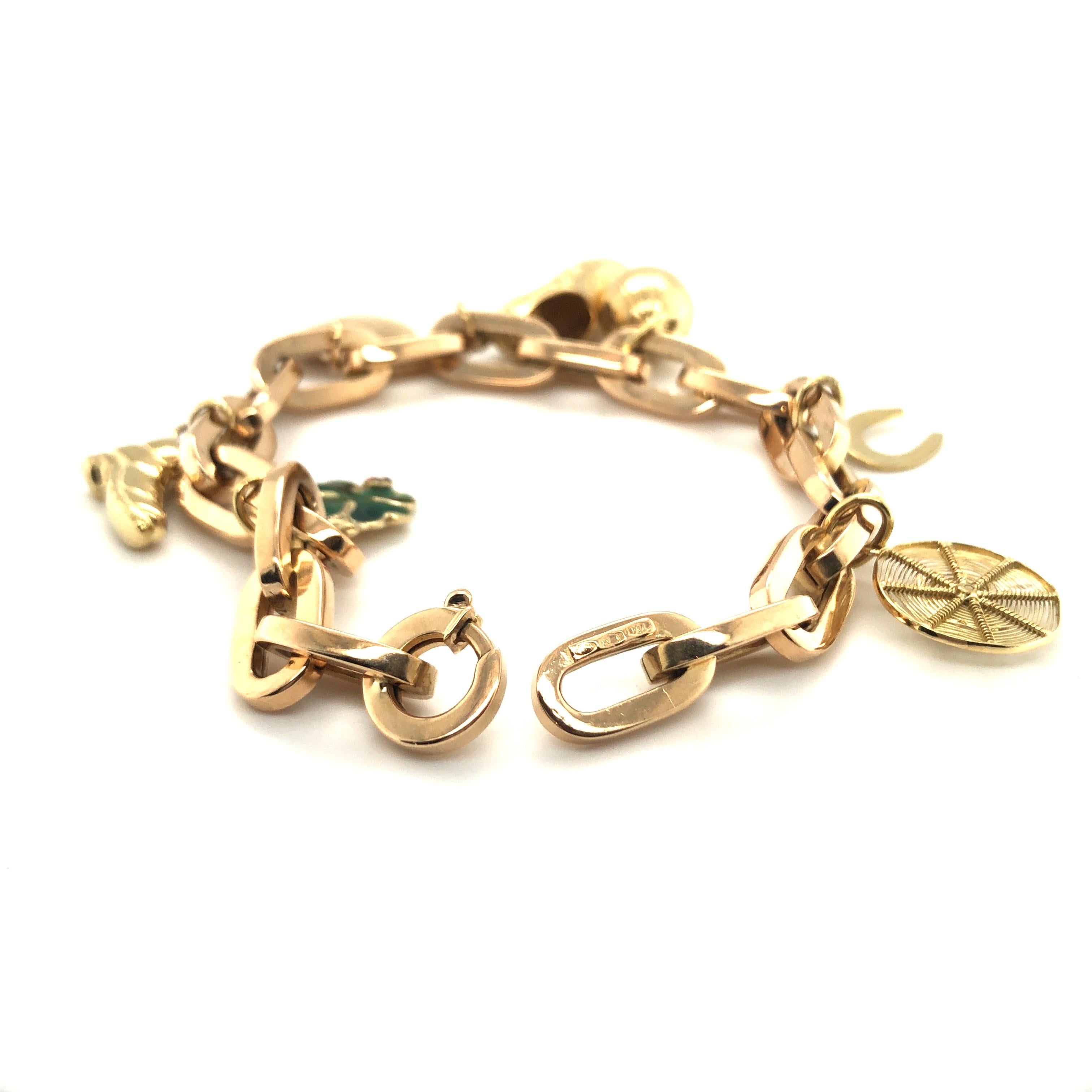 Lovely 18 karat yellow gold charm bracelet.
Anchor chain crafted in 18 karat yellow gold and adorned with 7 charms depicting a green enameled four-leaf clover, a climbing boot, an heart, a dutch clog, a ball, an horseshoe and a spider sitting on its