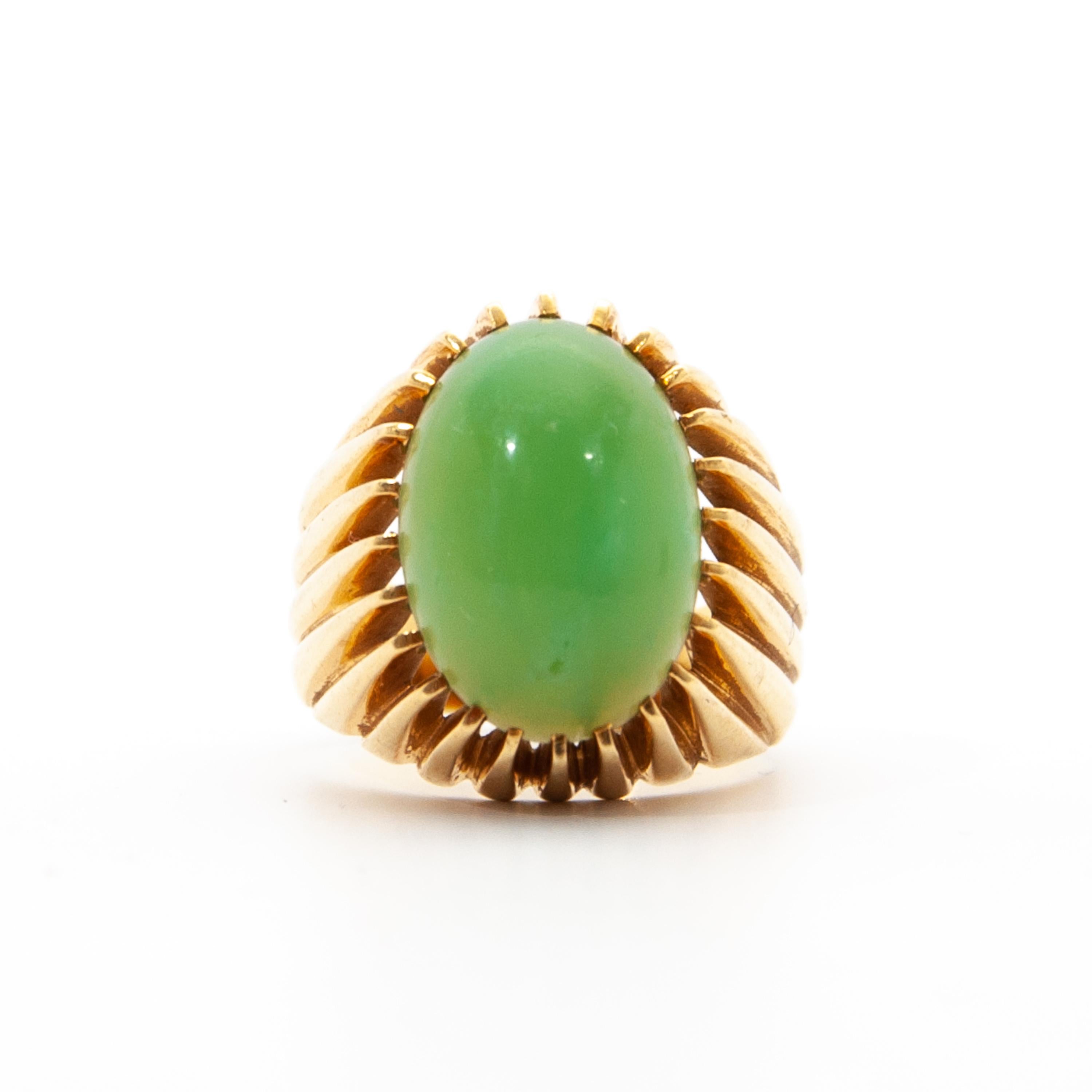 A vintage green chrysoprase ring created in 18 karat gold. The ring is characterized by the beautiful apple green color of this cabochon oval cut chrysoprase stone and the gold openwork vertical bars. The bars are forged into this descending and
