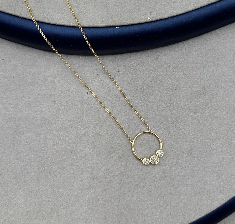 Wir zeigen unsere bezaubernde Diamant-Halskette mit kreisförmigem Charme, ein zartes Stück, das Ihrem Dekolleté einen Hauch von Eleganz verleiht. Diese mit Präzision und Sorgfalt gefertigte Halskette aus 18 Karat Gelbgold strahlt Wärme und