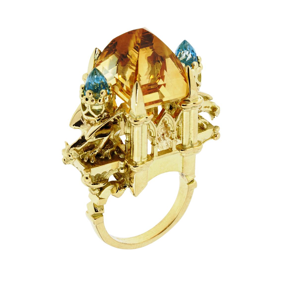 This majestic ring is a truly wondrous one of a kind piece.

Handcrafted in 18kt yellow gold this glorious ring features a central 16mm x 12.6mm radiant citrine of 20.98 carats, resplendent atop a signature William Llewellyn Griffiths cathedral