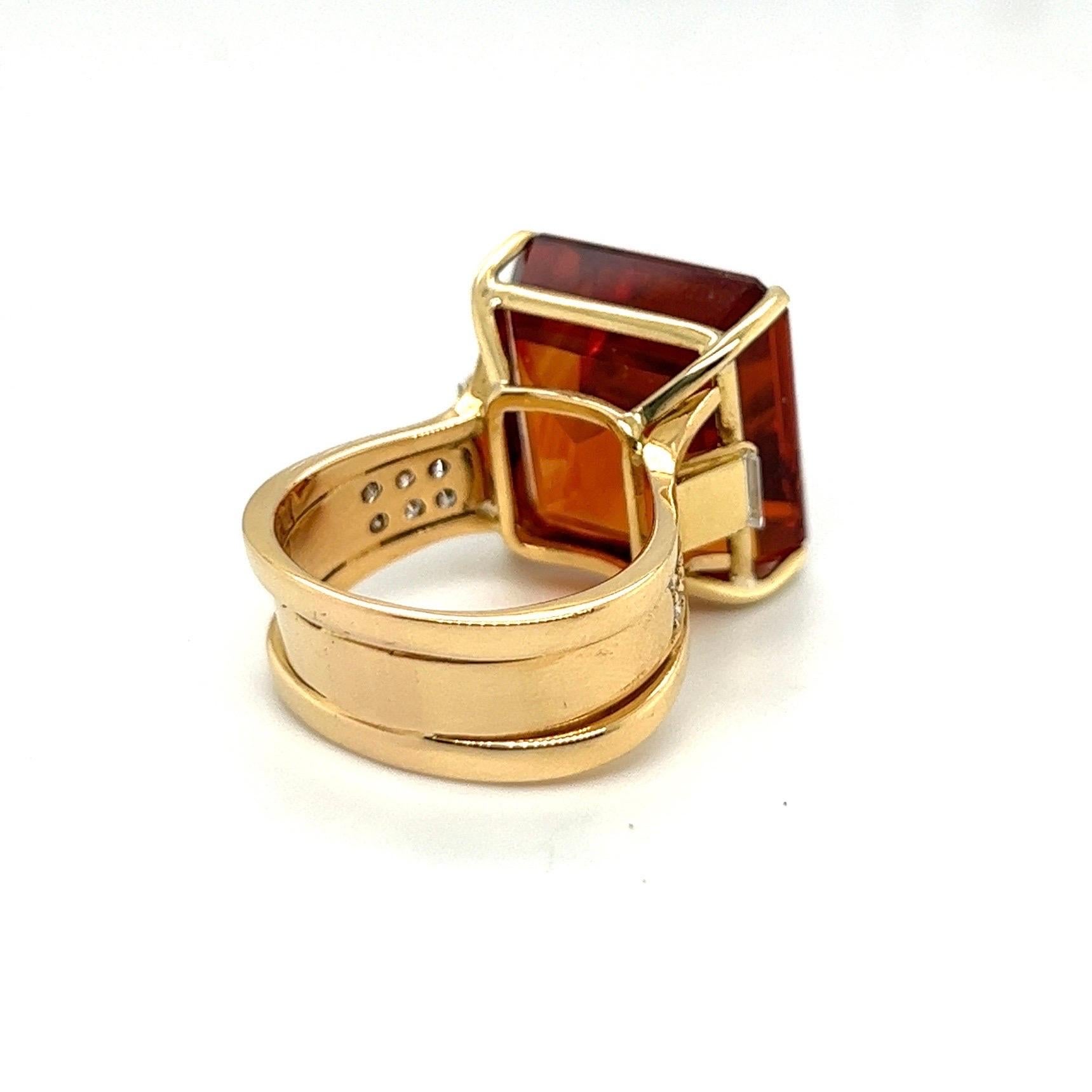 Eye-catching 18 Karat Yellow Gold Citrine and Diamod Cocktail Ring by Swiss jeweler Paul Binder, 1980s.

Of bold design, crafted in 18 karat yellow gold and set with an octagonal, step cut, honey-colored citrine of circa 22 carats flanked by two