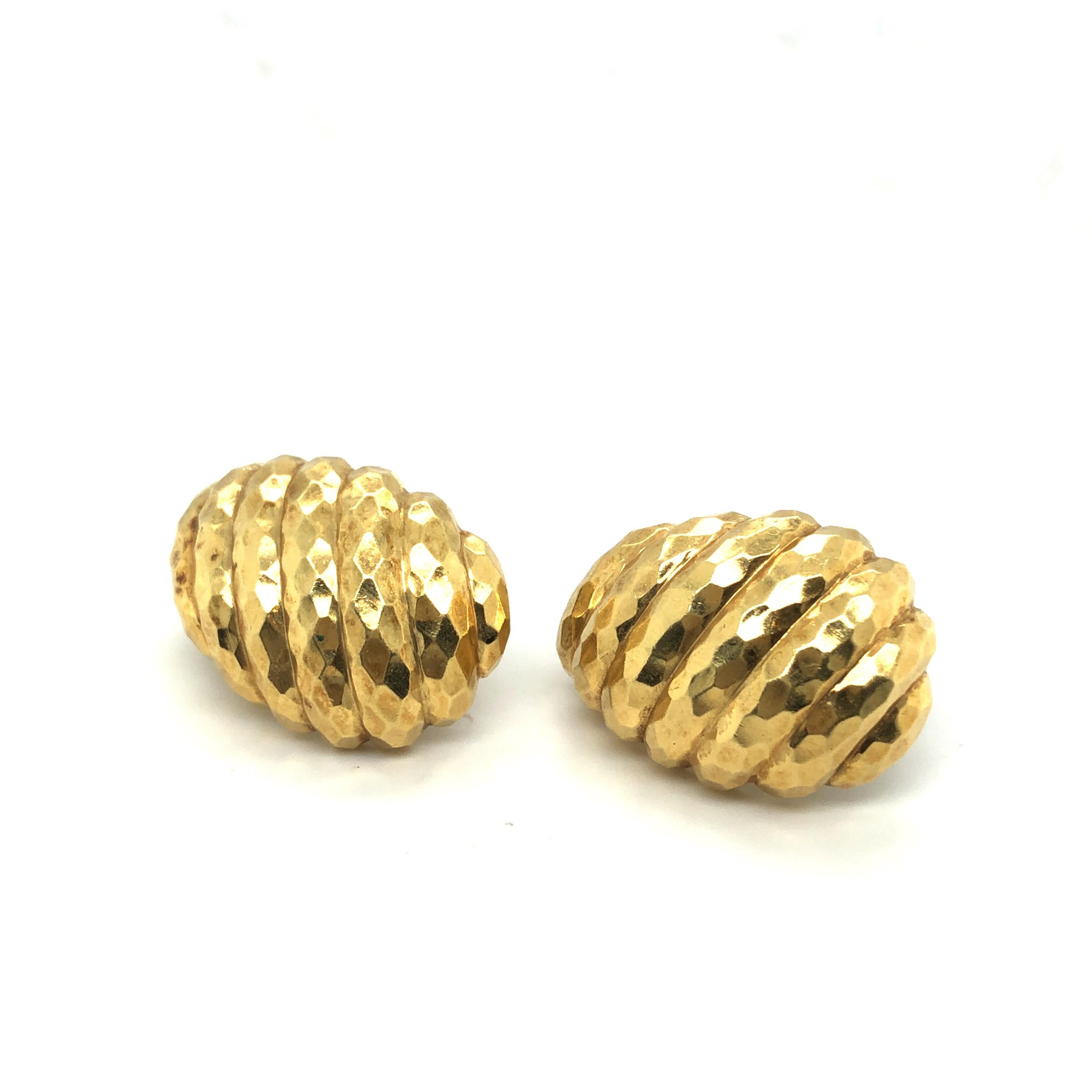 Stylish pair of 18 karat yellow gold hammered finish clip-on earrings by David Webb, New York.
Crafted in 18 karat yellow gold and designed as reeded and hammered half-hoops, these earrings are fitted with clips suitable for unpierced ears. 
David