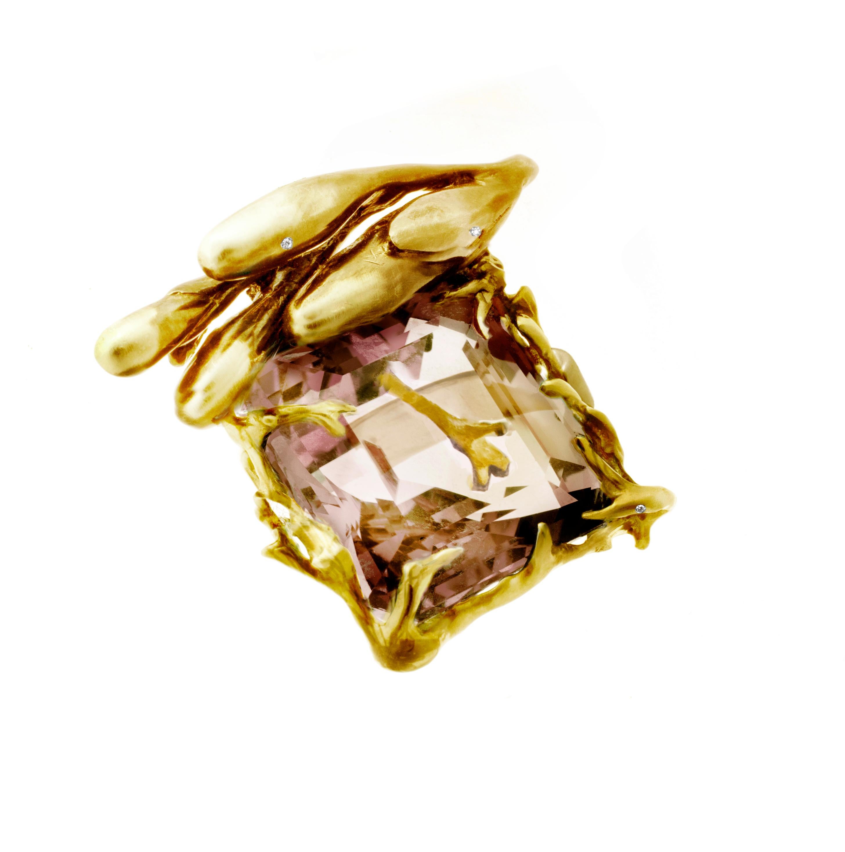 This is a Fairy Tale ring made of 18 karat yellow gold with a large Kunzite gemstone in a soft peach powder color. The ring has 7 diamonds encrusted in it and was featured in a published issue of Vogue UA. It was designed by artist and oil painter