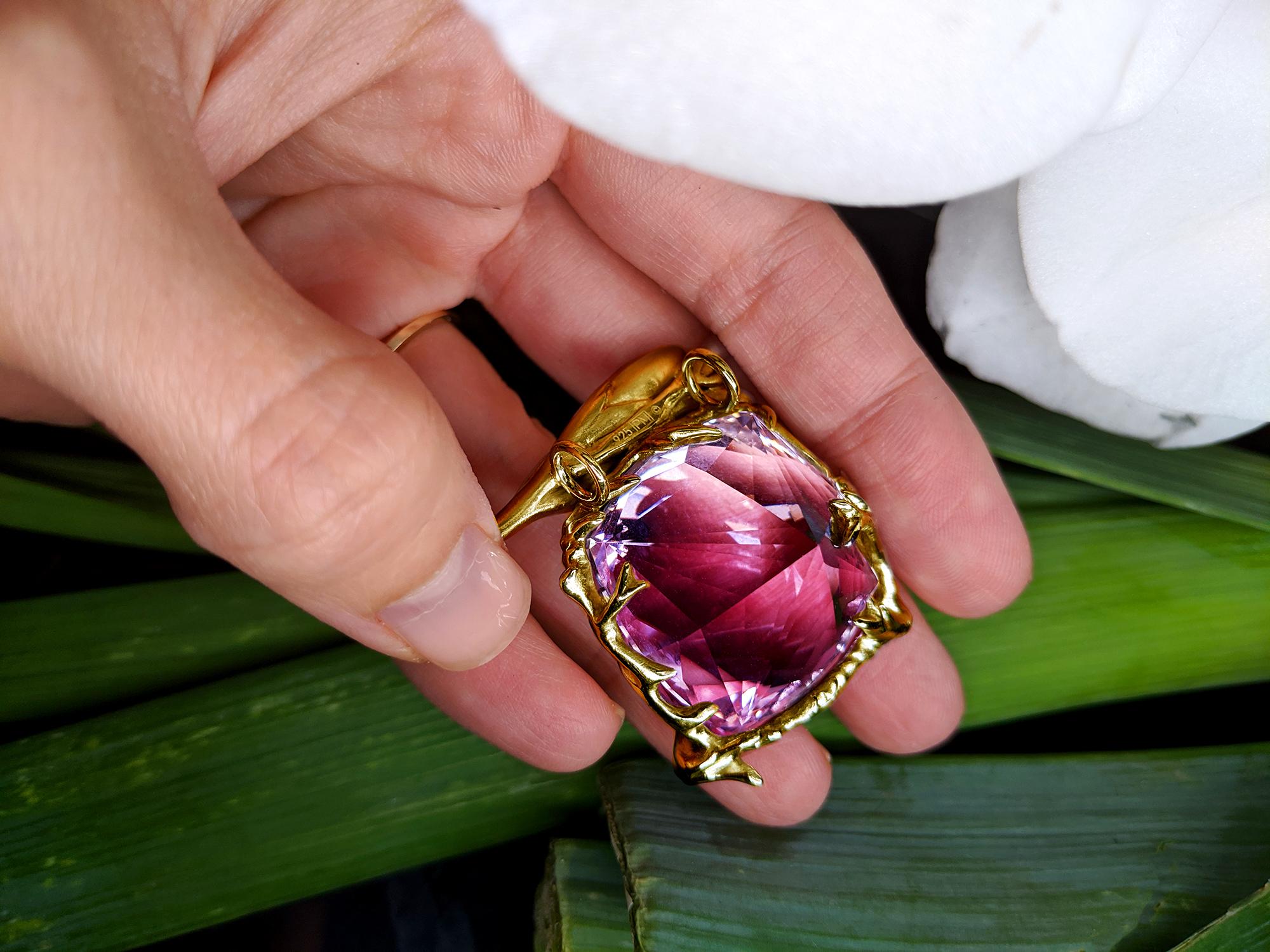 This Fairy Tale pendant necklace is a contemporary masterpiece designed by oil painter Polya Medvedeva. It is crafted from 18 karat yellow gold and features a giant cushion cut amethyst that radiates vivid lavender tones. The ring is adorned with