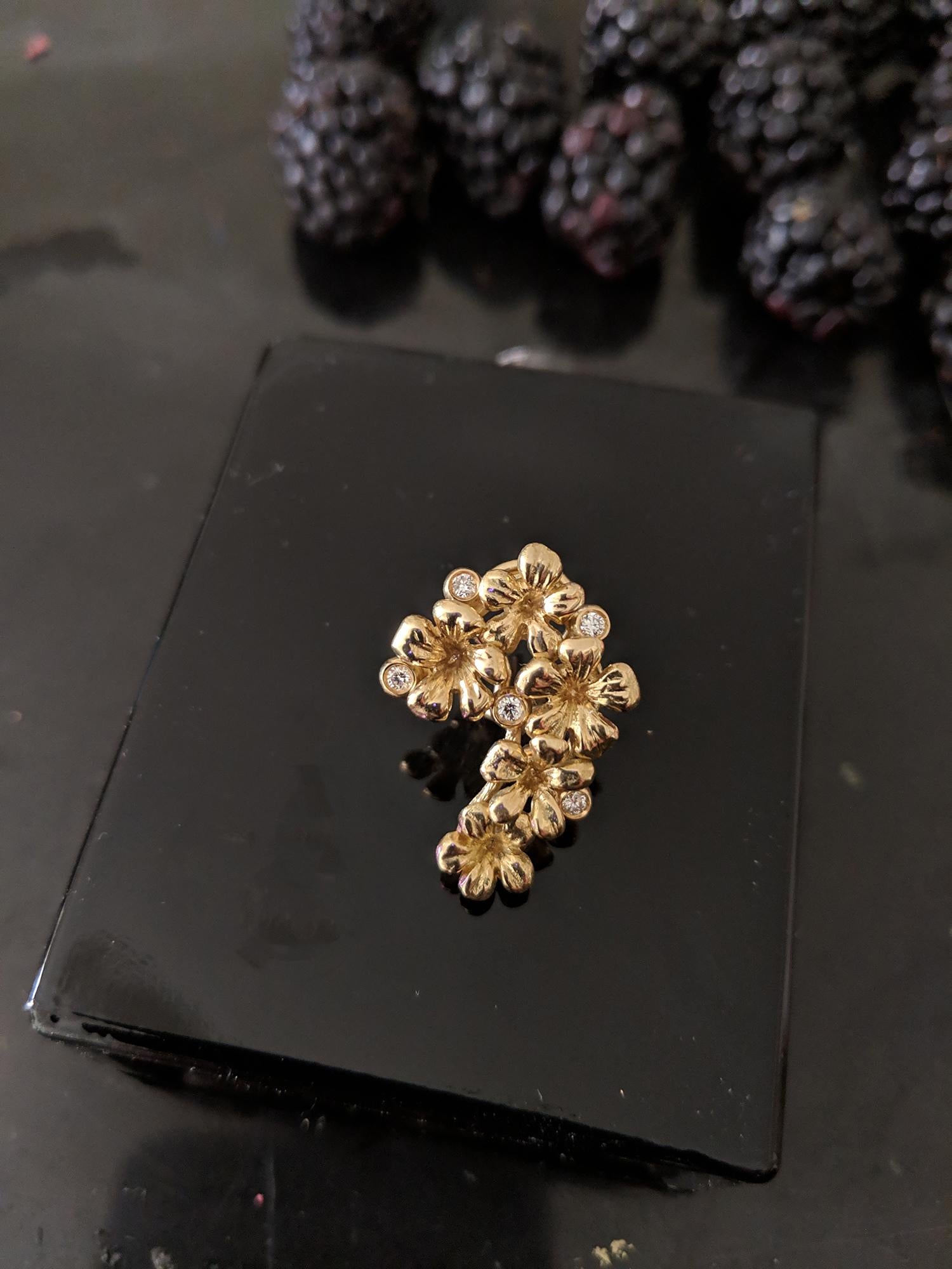 The Plum Blossom Modern Style brooch is made in 18 karat yellow gold. It features 5 round diamonds and a removable drop of natural rose tourmaline, which can be taken off. This beautiful piece of jewelry was featured in Vogue UA and was designed by