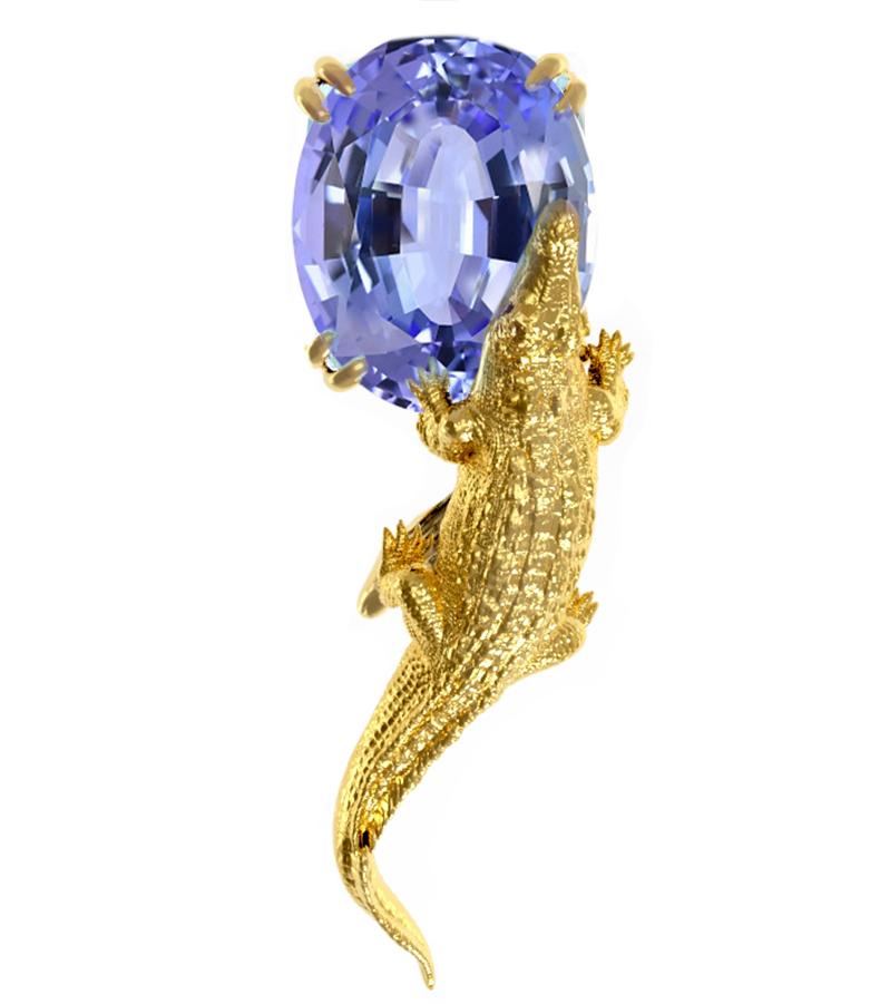 This contemporary brooch features an 18 karat yellow gold Mesopotamian design encrusted with a 1.82 carat natural oval cut blue tanzanite, 7.9x6.2x5.25 mm, certified by MGL. The gem is expertly showcased in a modern design that catches the