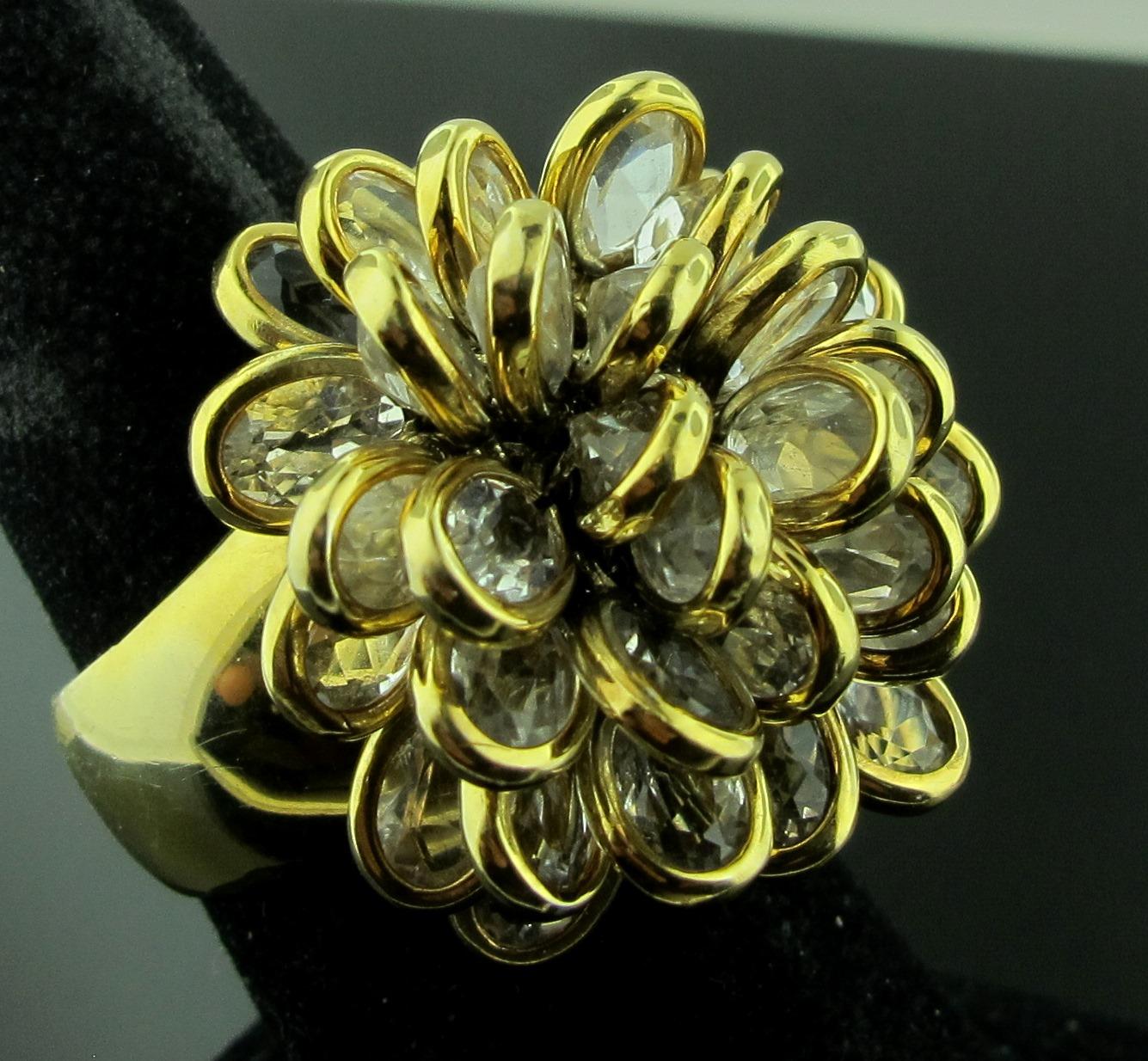 Signed Carla Amorin moving Floral Collection ring set with crystals in 18 karat yellow gold.  Ring size is 7.25.