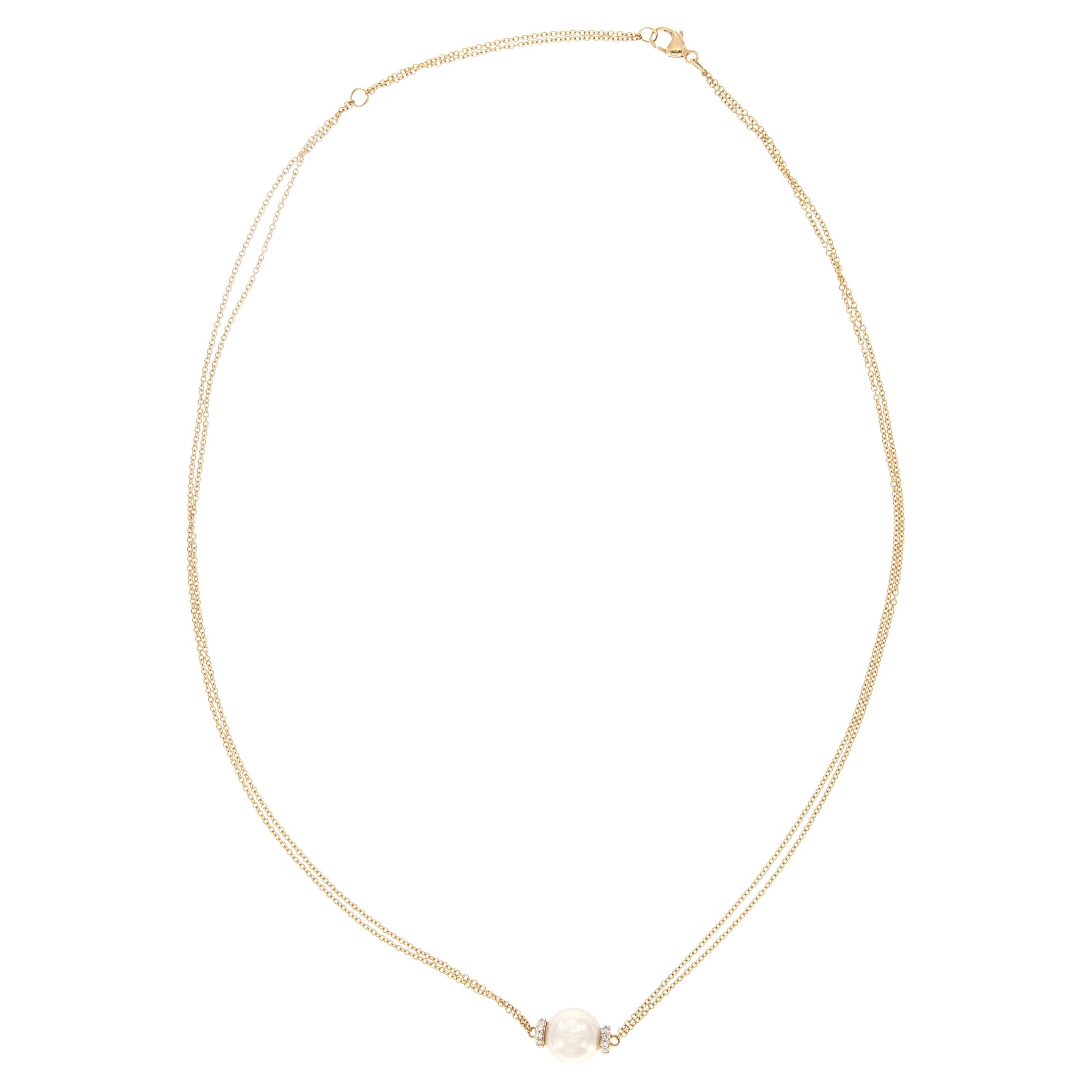 Classic necklace made from rich 18 karat yellow gold with one single 9.5mm freshwater pearl accented  with 21 diamonds = 0.12 cttw. Pearl and diamonds roll while you wear it for a fun, eye catching look! Suspended on a double cable chain 18