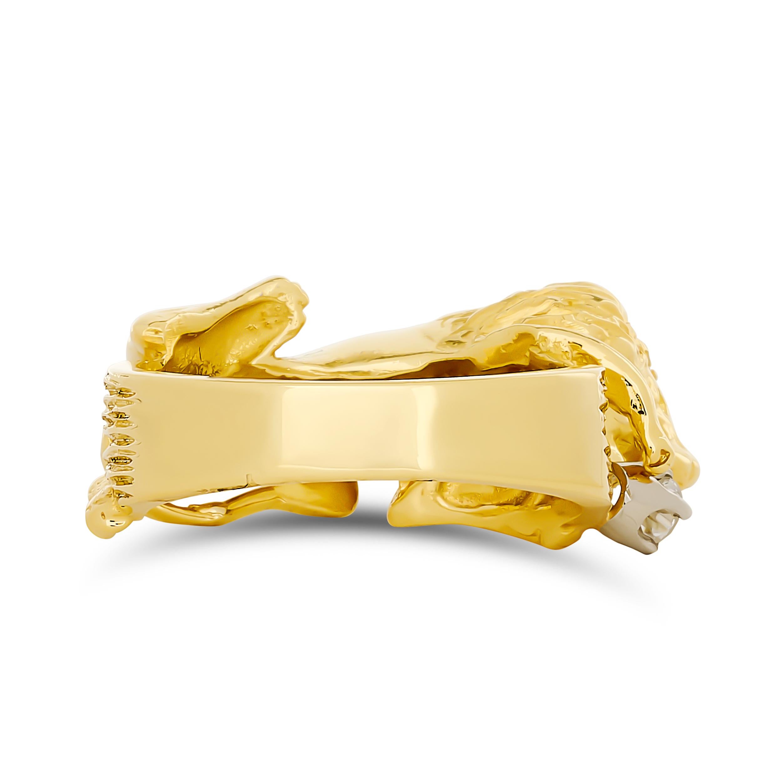 Cette bague distinctive en or jaune présente une sculpture de lion détaillée et tridimensionnelle serrant de manière spectaculaire un diamant de taille brillant, formant ainsi une pièce unique et frappante.

1 diamant rond d'environ 0,10 carat, de