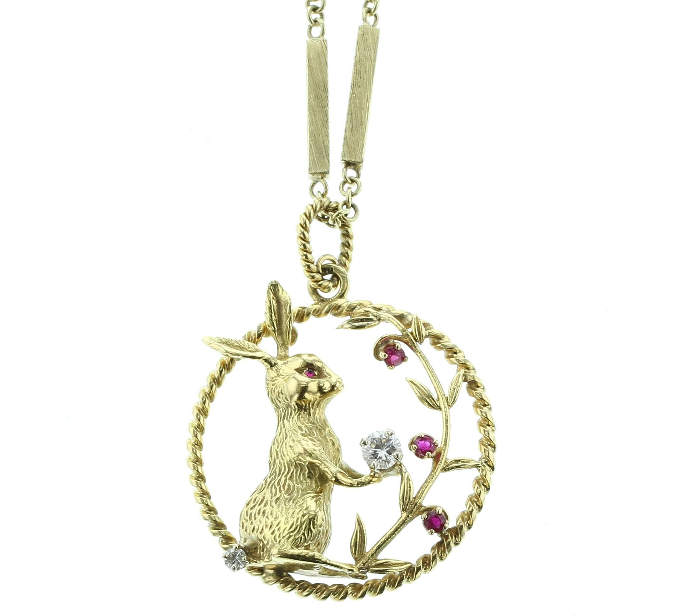 A beautiful pendant with a ruby-eyed bunny holding a diamond (appx 0.40 cts) and a diamond tail (appx. 0.10 cts) with three rubies on the leaves, in 18K Yellow Gold. Chain measures 36