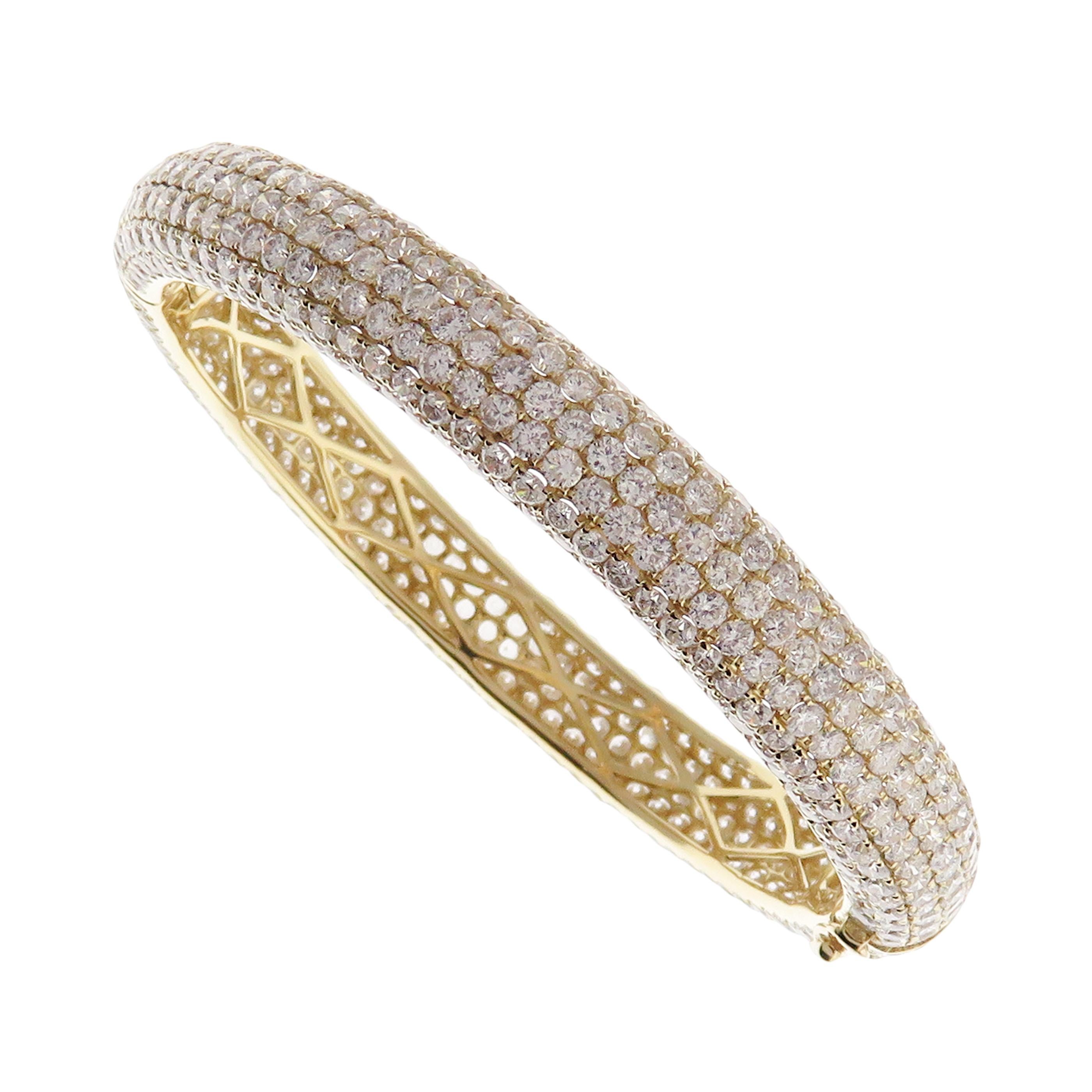 This classic pave bangle is crafted in 18-karat yellow gold, weighing approximately 20.05 total carats of V-Quality white diamonds. This bangle has diamond all around for a 