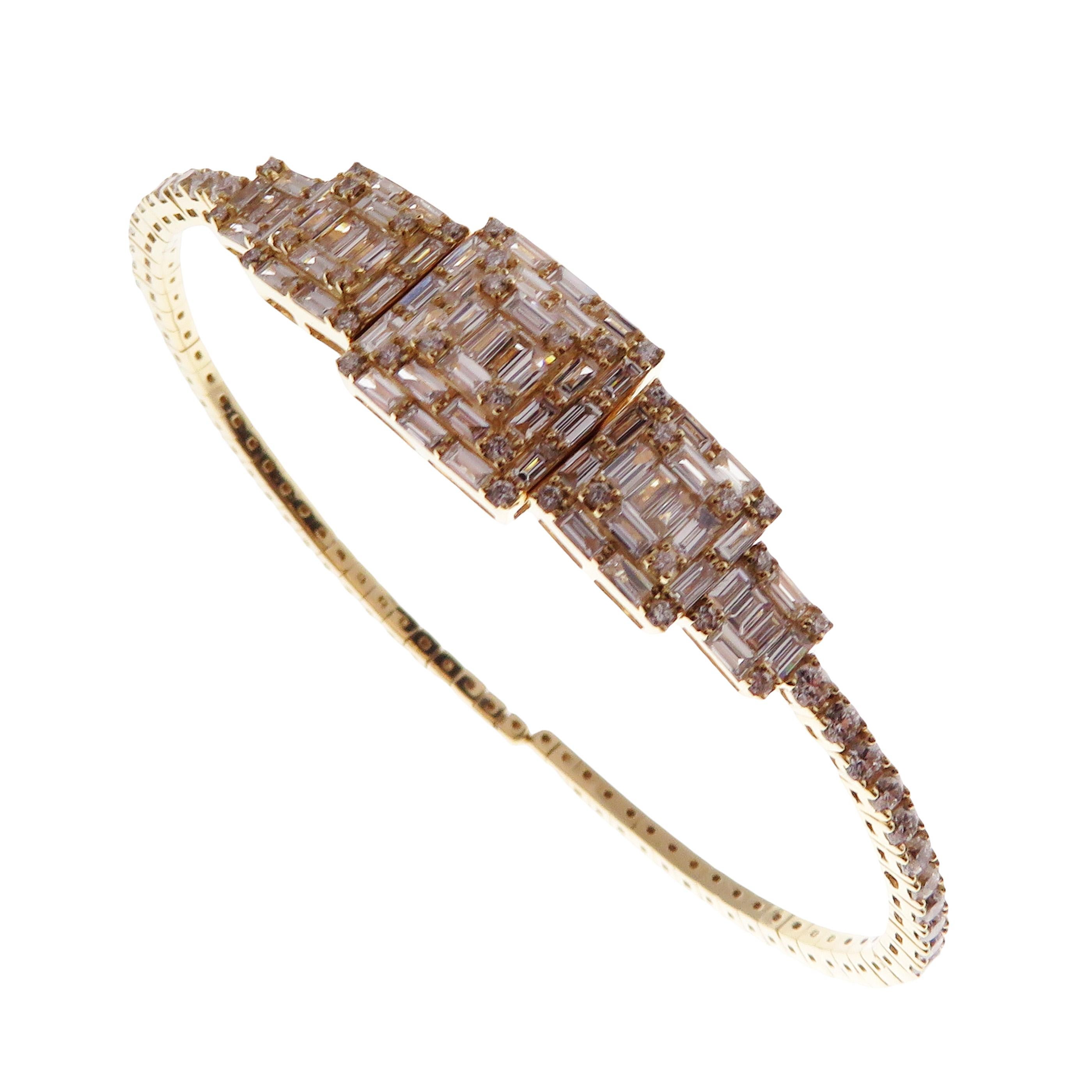 This gradating baguette bangle is crafted in 18-karat yellow gold, weighing approximately 2.76 total carats of V-Quality white diamond. Flexible open back with optional interlocking closure

Fits wrists up to 6.25-6.50