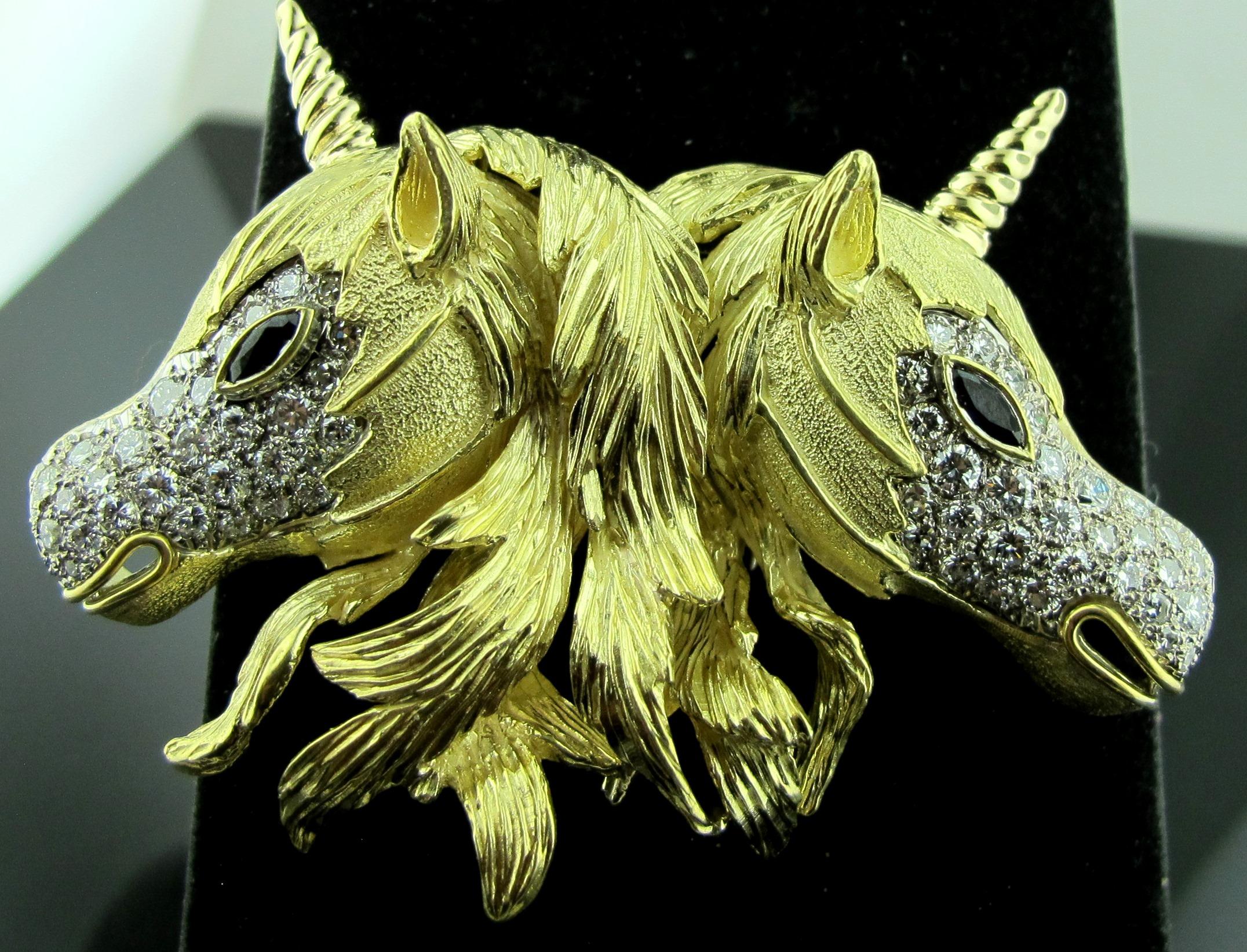 Double Diamond Unicorn Brooch. Set in 18 karat yellow gold, weighing 47 grams.  There are 64 round brilliant cut diamonds, with a total weight of approximately 2.75 carats.  Color: F-G, Clarity: VS-1.  The eyes are marquise cut blue sapphires. 