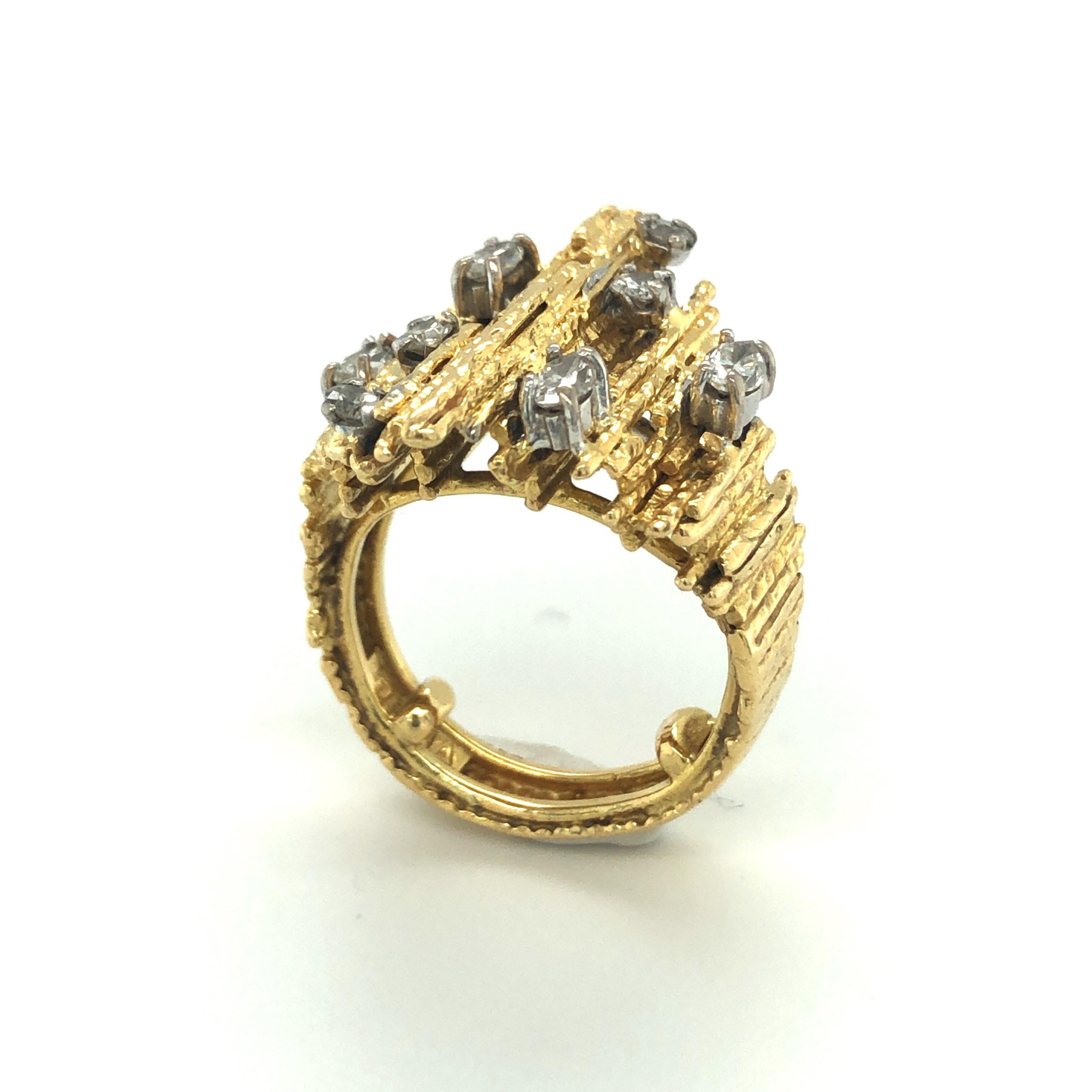 18 karat yellow gold diamond dress ring by Andrew Grima, 1976.
Of abstract design, the textured wire gold mount embellished with 4 marquise and 4 brilliant-cut diamonds totalling circa 0.5 carats. The textured surface is typically featured in jewels