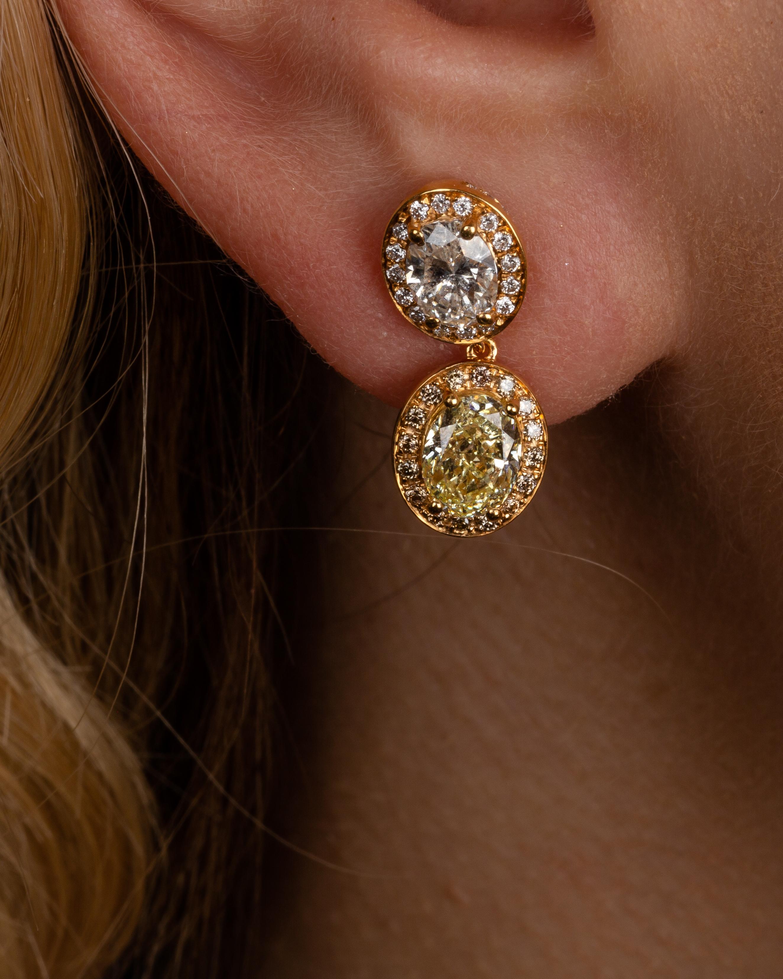 This 18K yellow gold classy drop earrings are from our Divine Collection. It is a perfect combination of a 2 oval shape yellow diamonds in total of 1.39 Carat and 2 oval shape colourless diamonds in total of 0.96 Carat. All the diamonds are