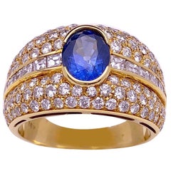 Anello in oro giallo 18 carati con diamante e zaffiro blu ovale centrale da 1,47 carati