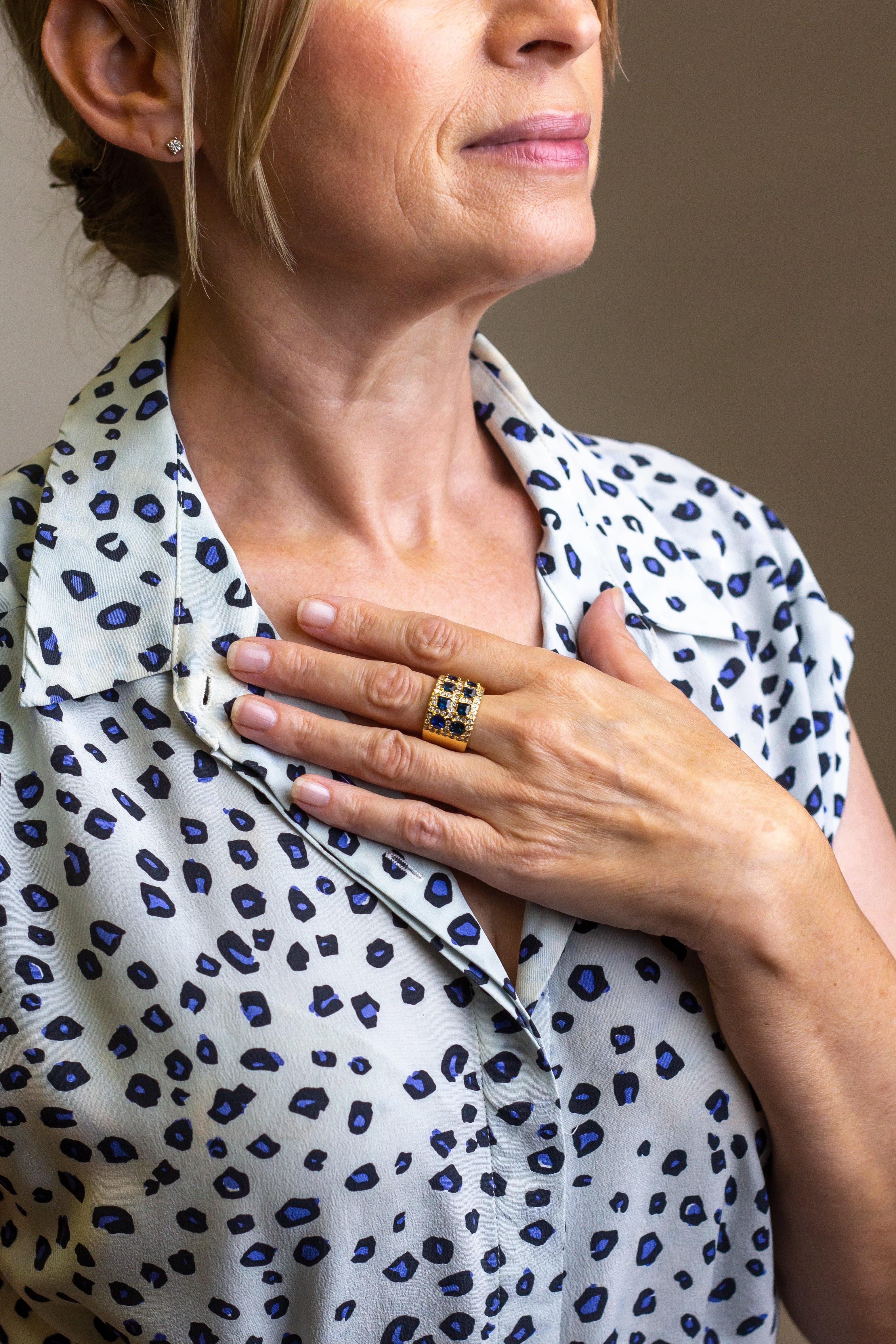 A sizeable yellow gold, diamond and sapphire 'latticework' style 'plaque' ring. The 18 karat yellow gold setting is claw set with eight carrae cut sapphires which are positioned in two rows. These rows are interspersed with 59 hammer set, brilliant