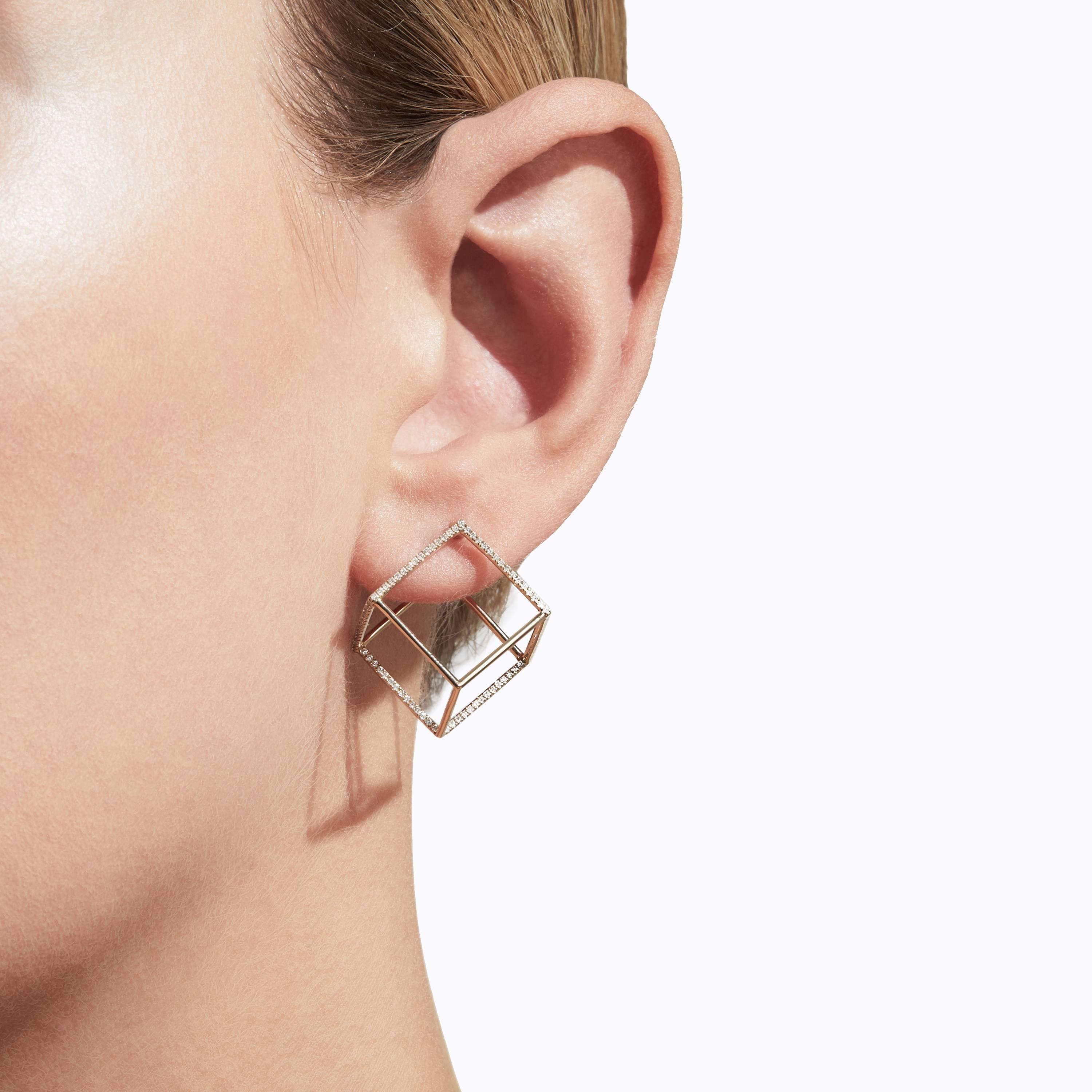 The three dimensional cubic form appears to float seamlessly around the earlobe when worn. One side is an earring post and six lines are set with micro diamonds creating a subtle but luxurious effect. You can alter the point at which the earring
