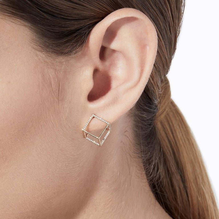 The three dimensional cubic form appears to float seamlessly around the earlobe when worn. One side is an earring post and six lines are set with micro diamonds creating a subtle but luxurious effect. 

18 Karat Yellow Gold Diamond Square Pair of