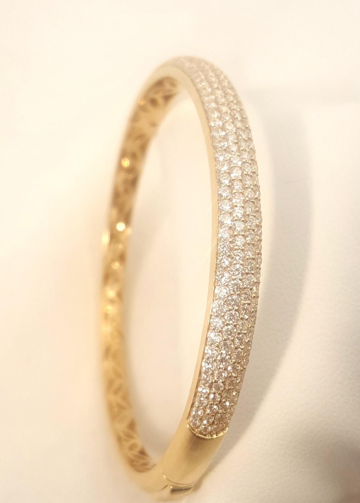 Brand new! Crafted in 18 karat yellow gold, this tapered bangle boasts a top section containing 172 round white diamonds, pave set, with a combined total weight of 2.32 carats.  The sparkle is eye popping!  A double 'click' hidden clasp assures