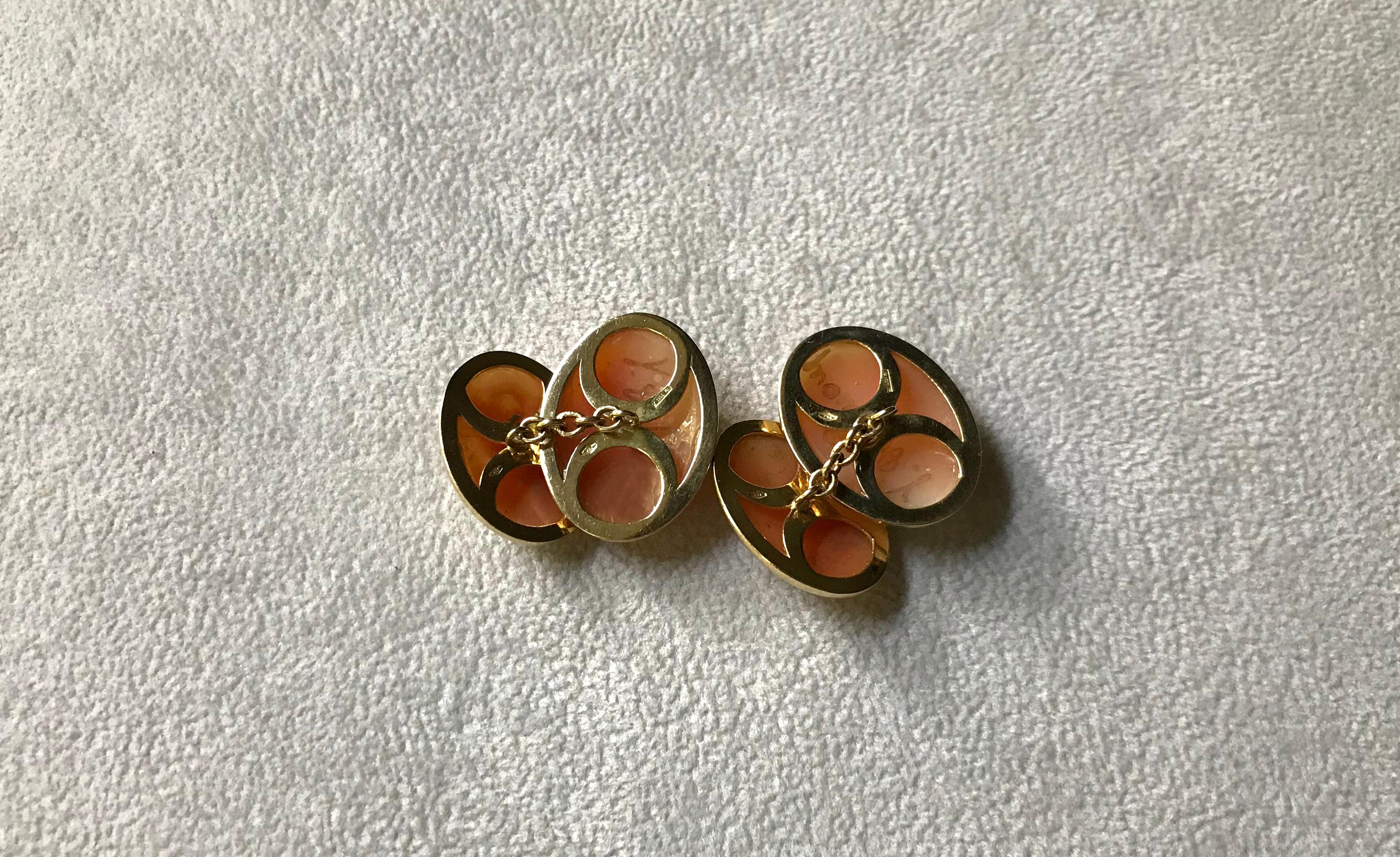 This exquisite pair of cufflinks is comprised of front face and toggle both made using cammeos, whose unique elegance give a classic allure to the piece. 
The warm orange/ red of the background and white color of the charming figurines in profile