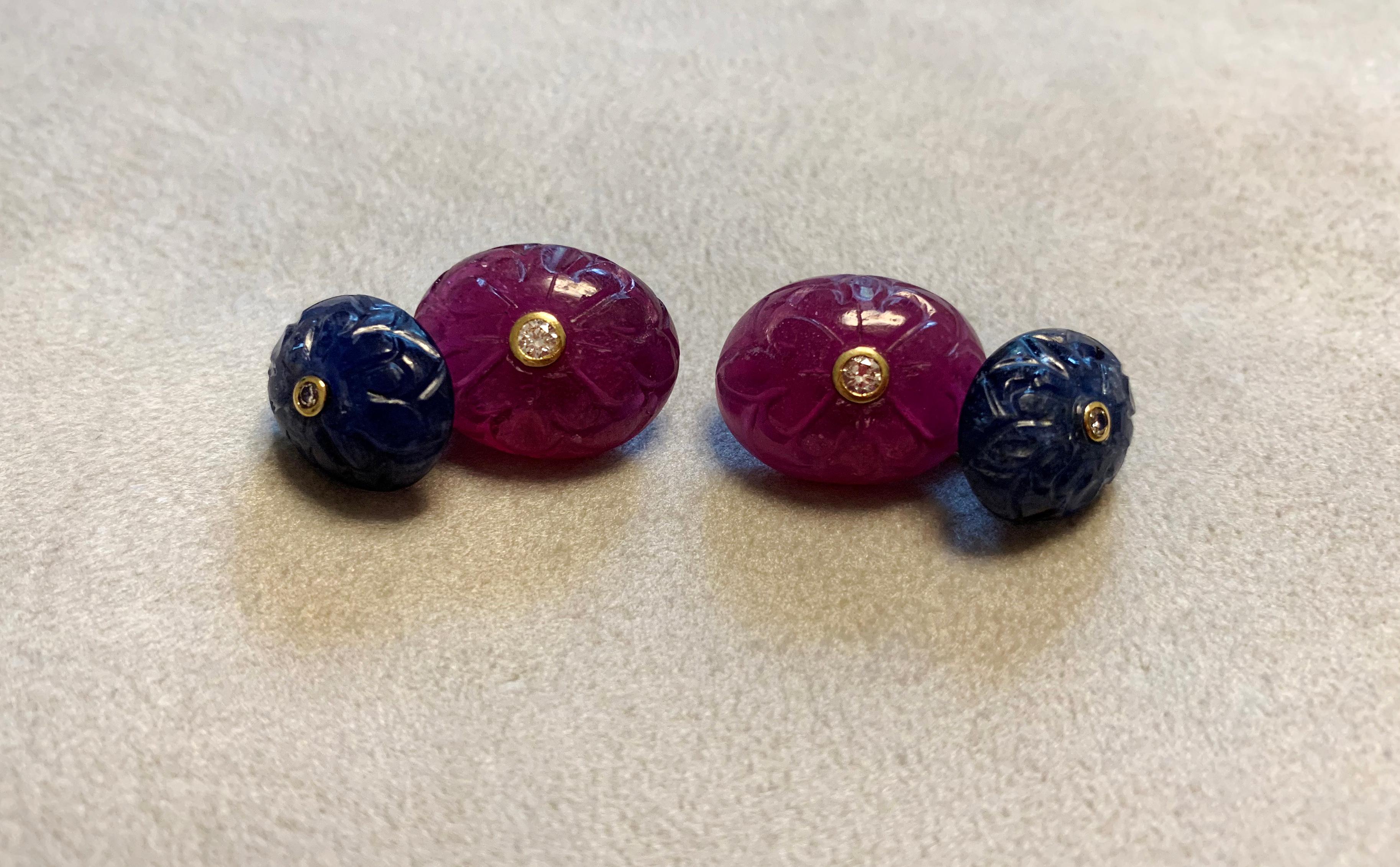 This classic and beautiful pair of cufflinks is sophisticated and timeless. 
Both toggle and front face are shaped as ovals made of sapphire and rubies that were masterfully carved with an abstract decoration. 
The center of each element is