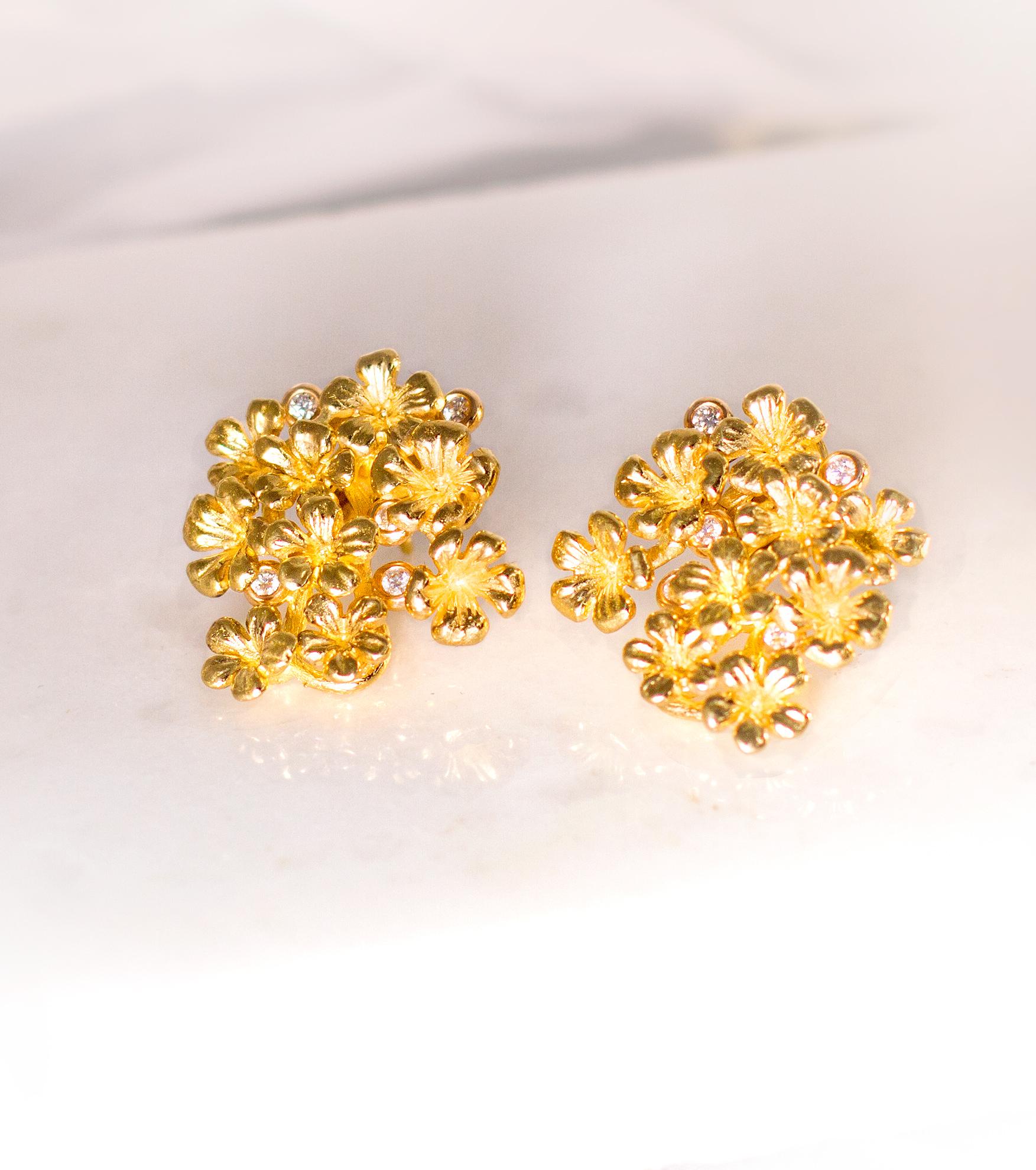 These contemporary Plum Flowers cocktail earrings are made of 18 karat yellow gold and are encrusted with 10 round diamonds. They also come with detachable neon blue paraiba tourmalines in pear cut, 5 carats in total, each measuring 11x7.5 mm. This