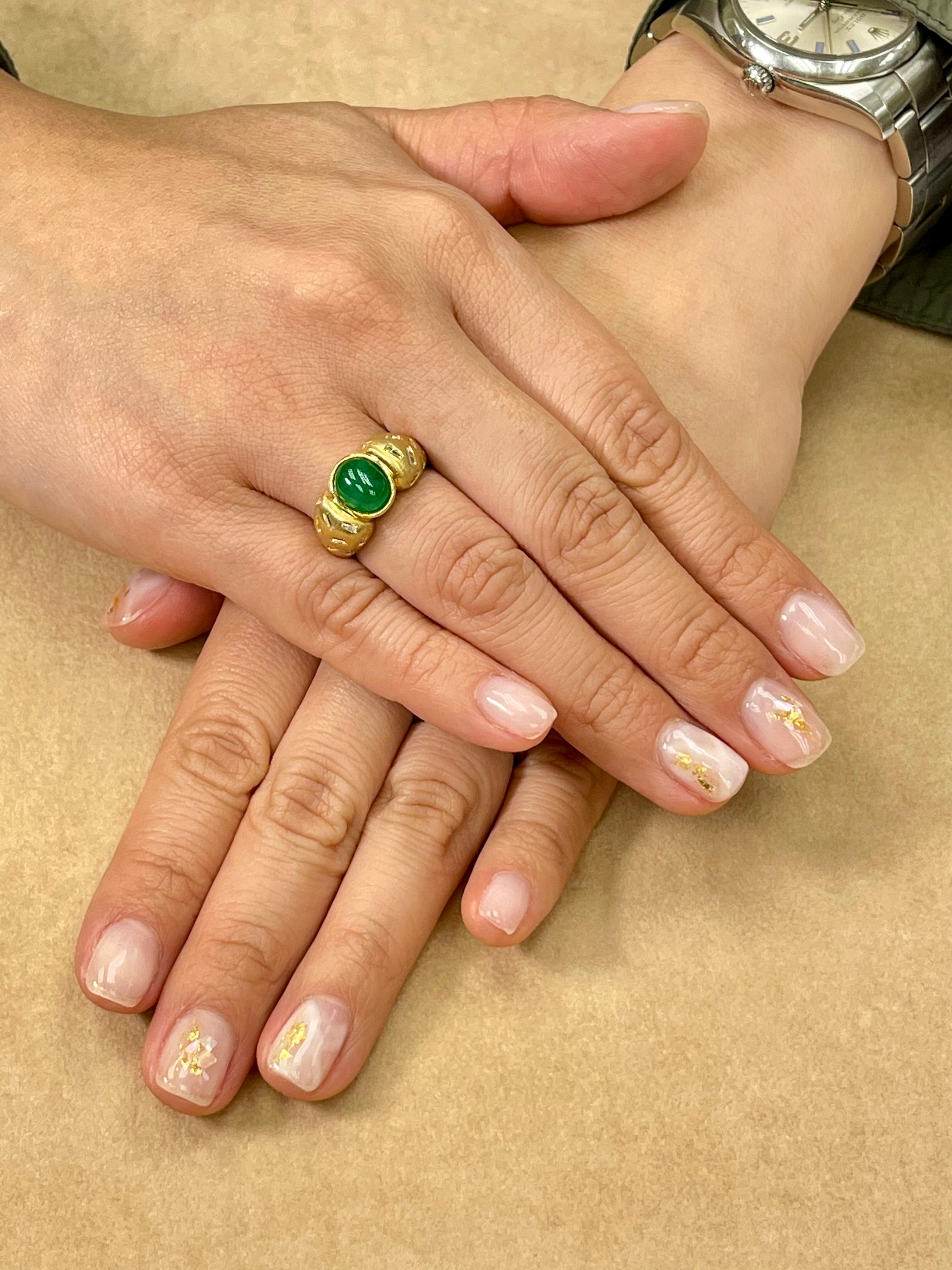 Here is a nice Emerald and diamond ring. The ring is set in 18k yellow gold and white diamonds. The center cabochon emerald is estimated to be about 1.5 Cts. There are 20 tapered baguette diamonds embedded in the shanks of the ring. We