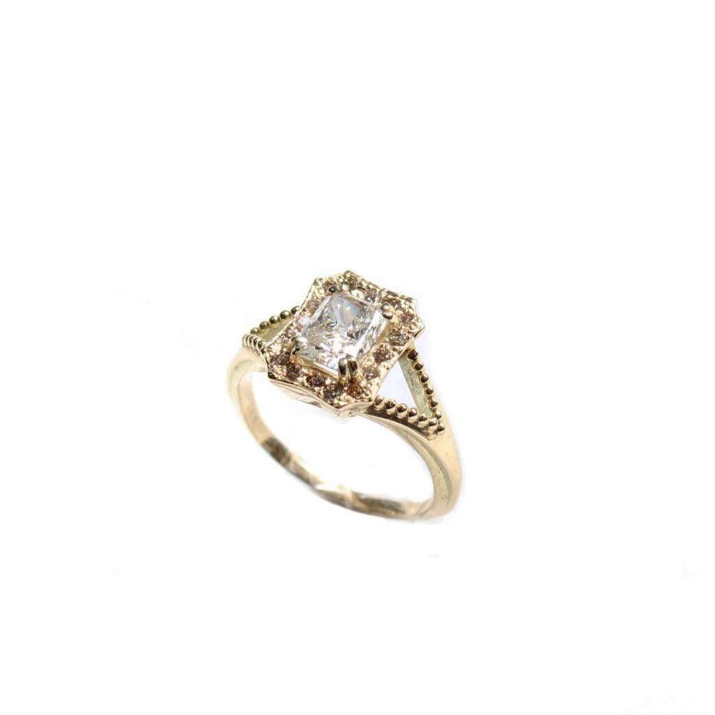 Gorgeous vintage inspired diamond ring with a split shank and granular beading. A radiant cut .82 carat diamond is set in solid 18 carat yellow gold. A champagne colored halo of diamonds surrounds this radiant cut gem in a low profile. Timeless