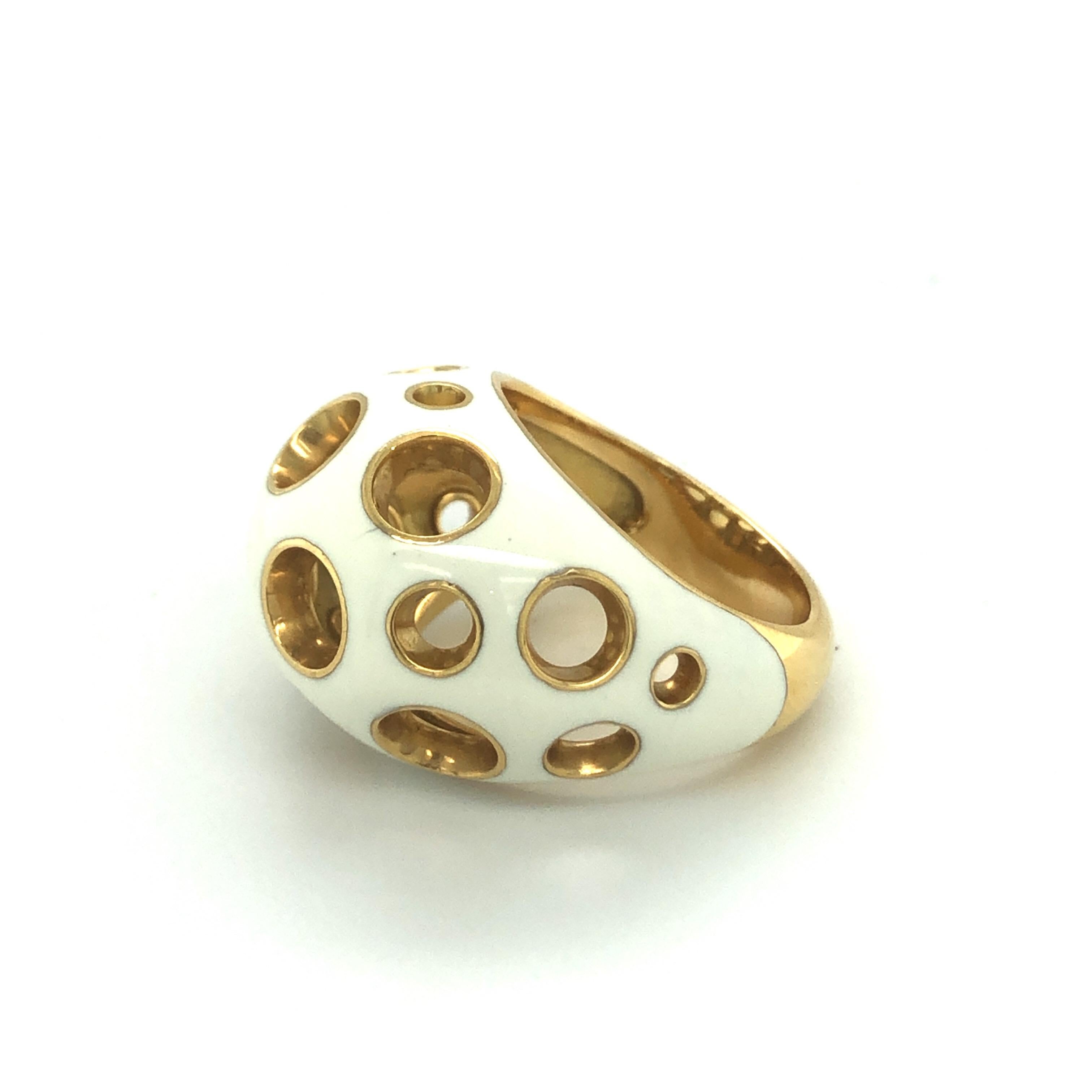 Stylish 18 karat yellow gold and enamel cocktail ring by Mellerio.
Dome ring crafted in 18 karat yellow gold. The ring head is covered with a layer of cream coloured enamel and interspersed with cut-out circles of different sizes. It is light,