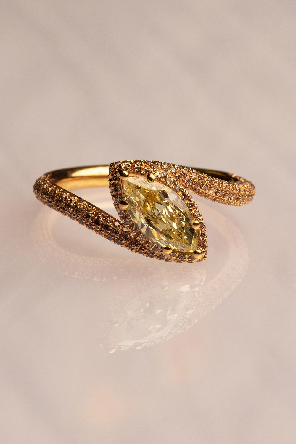 This 18K yellow gold elegant cocktail ring is from our Divine Collection. The centre stone is marquise shape fancy yellow diamond in total of 1.19 Carat which is decorate by round brown diamonds in total of 0.52 Carat. Total metal weight is 3.66 gr.