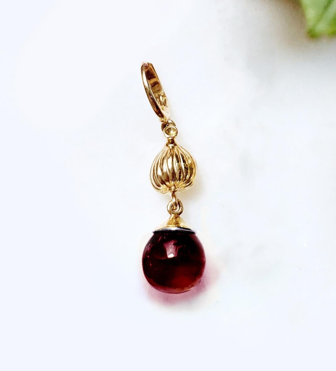 This Fig Garden necklace pendant with the cabochon garnet is made of 18 karat yellow gold. This collection was featured in Vogue UA. It is limited edition collection of jewellery by artist, with the unusual design and the gem open for the